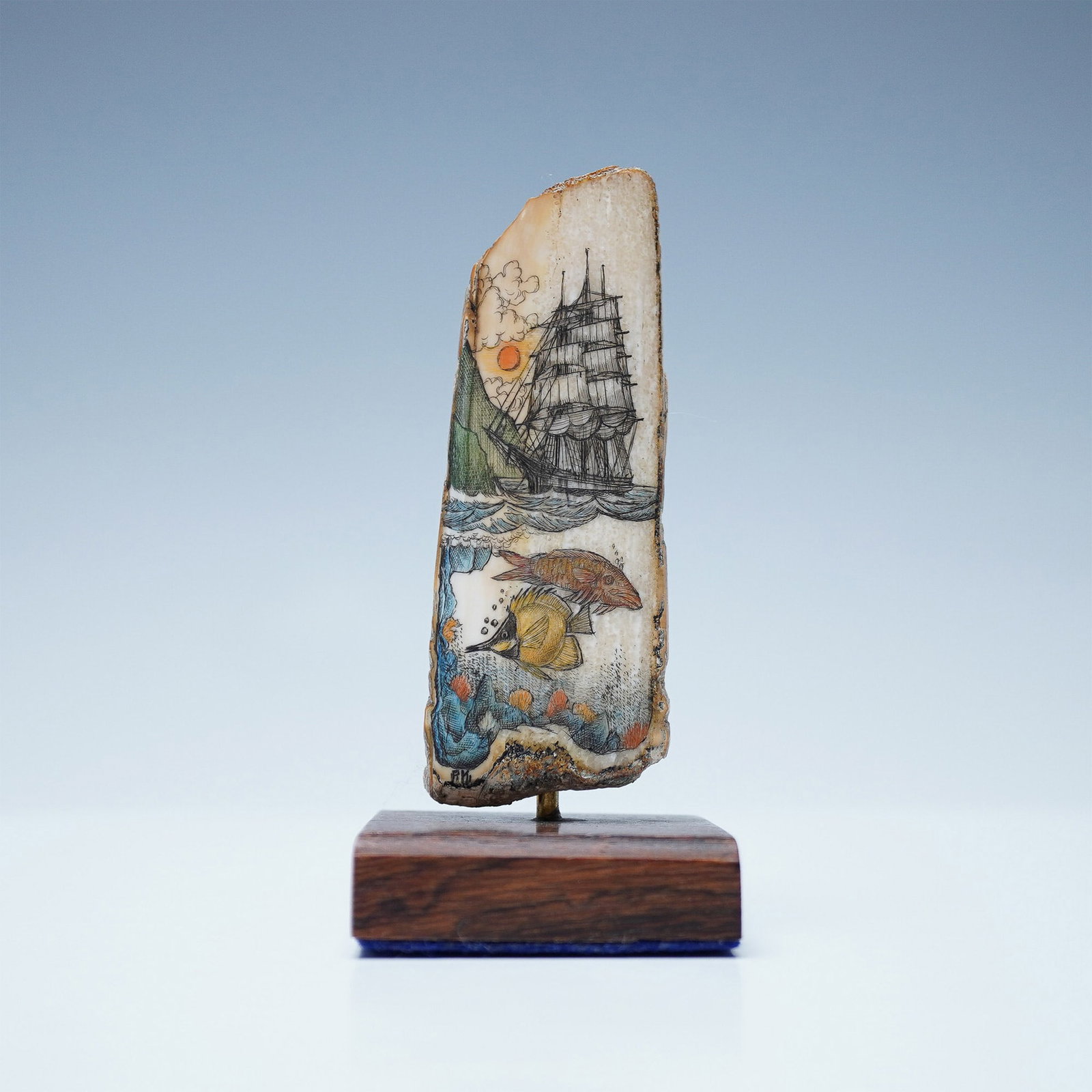 Peter Kinney, Fossilized Walrus Tusk Scrimshaw, Signed: Scrimshaw artwork by Peter Kinney on a fossilized walrus tusk, titled Sunset Voyage. The hand-etched and colored design features a maritime scene depicting a sailing ship at sea with a sun setting beh