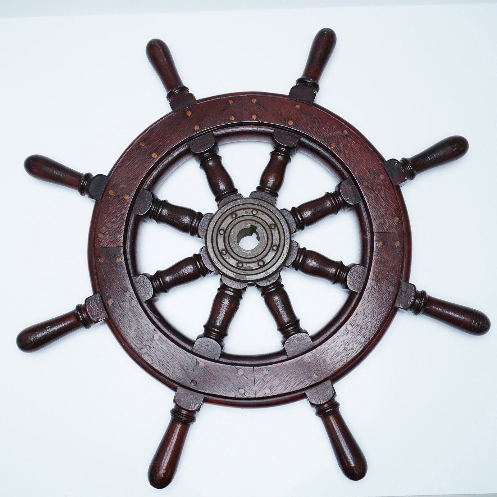 Vintage Wooden Ship's Wheel with Brass Hub: This vintage wooden ship's wheel features a classic eight-spoke design with a solid brass hub, showcasing maritime craftsmanship. The richly stained hardwood is accented with brass inlays, adding to i