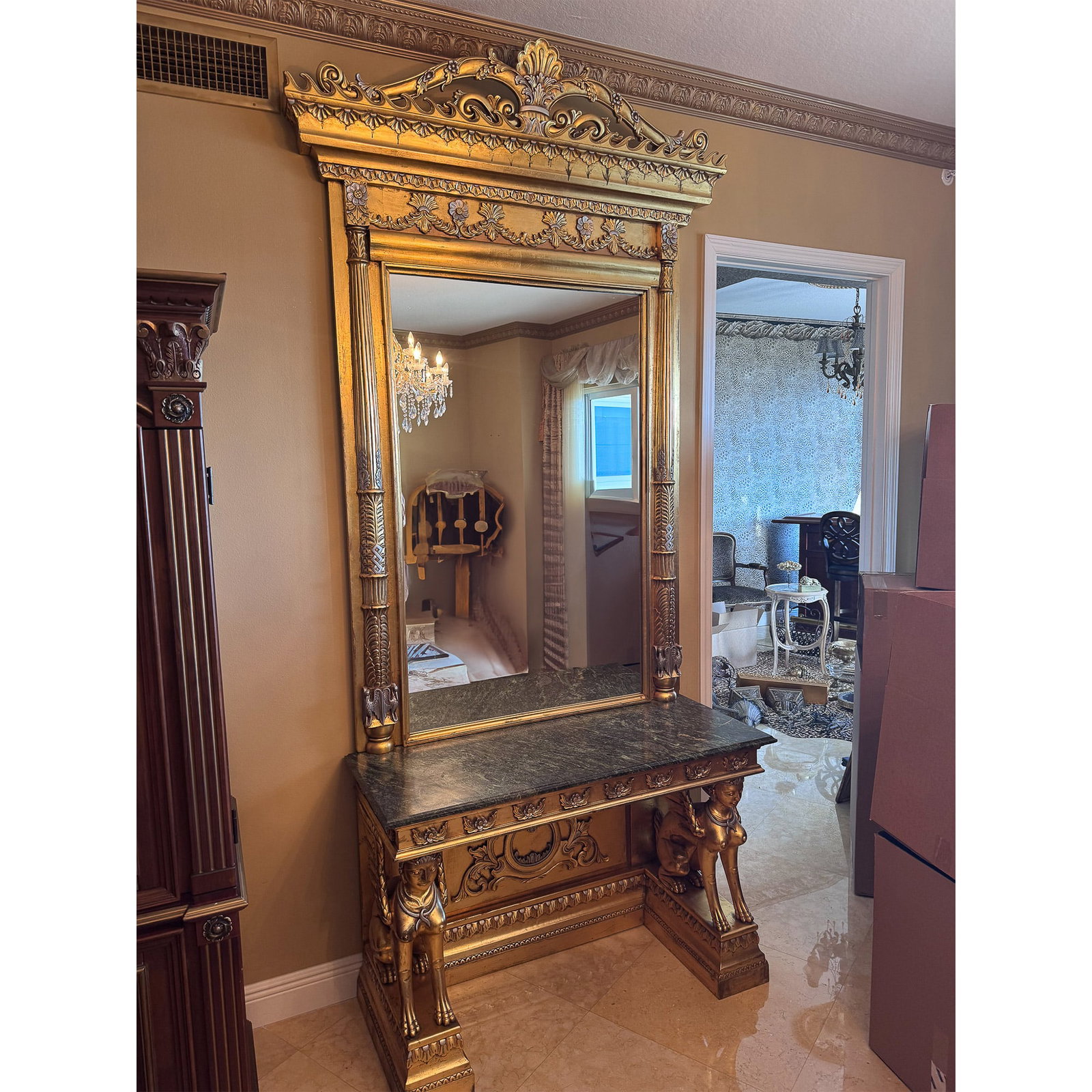 Neoclassical Style Giltwood Console Table w/ Sphinx & Mirror: Majestic neoclassical-style console table with a towering mirror, featuring an opulent giltwood frame adorned with intricate floral motifs, scrolling acanthus leaves, and classical detailing. The stri