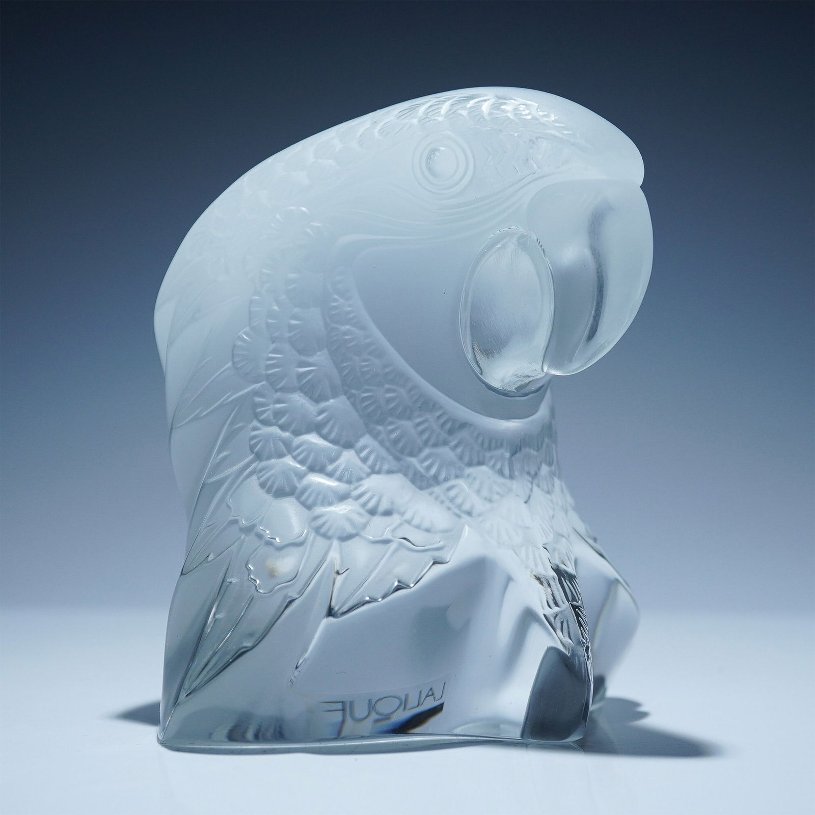 Lalique Frosted Crystal Paperweight, Parrot Head: Lalique frosted crystal paperweight featuring a detailed parrot head design with intricate feather textures and a gracefully curved beak. This stunning piece exemplifies Lalique's artistry in glassmak