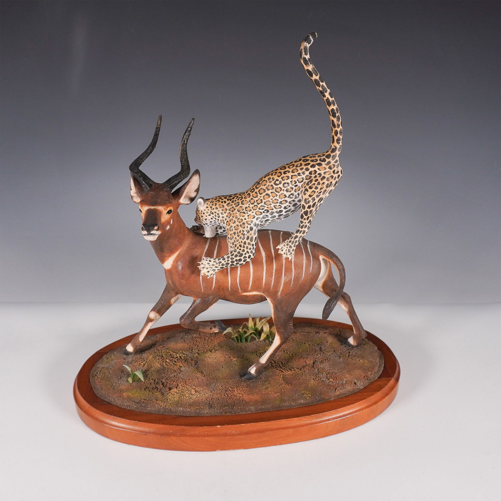 Louis Paul Jonas Studios Limited Edition Leopard and Bongo Sculpture: A rare and striking Louis Paul Jonas Studios wildlife sculpture depicting a leopard in mid-pounce, ambushing a bongo. This dynamic and highly detailed sculpture captures the raw intensity of a predato