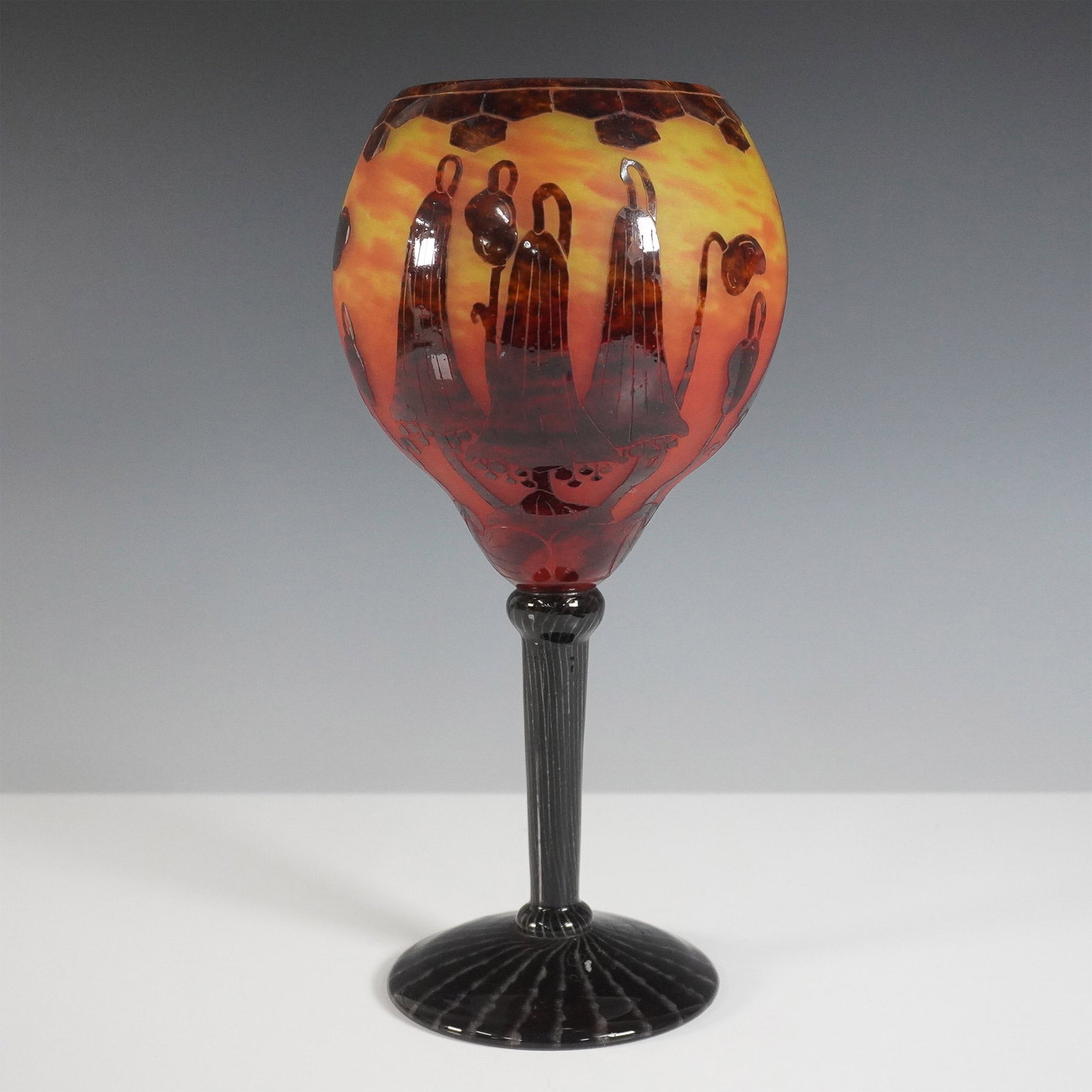 Le Verre Francais Cameo Glass Goblet Vase: A striking Le Verre Francais cameo glass goblet vase, featuring an intricate acid-etched design of stylized floral motifs against a fiery orange and deep red background. The goblet-shaped bowl sits at