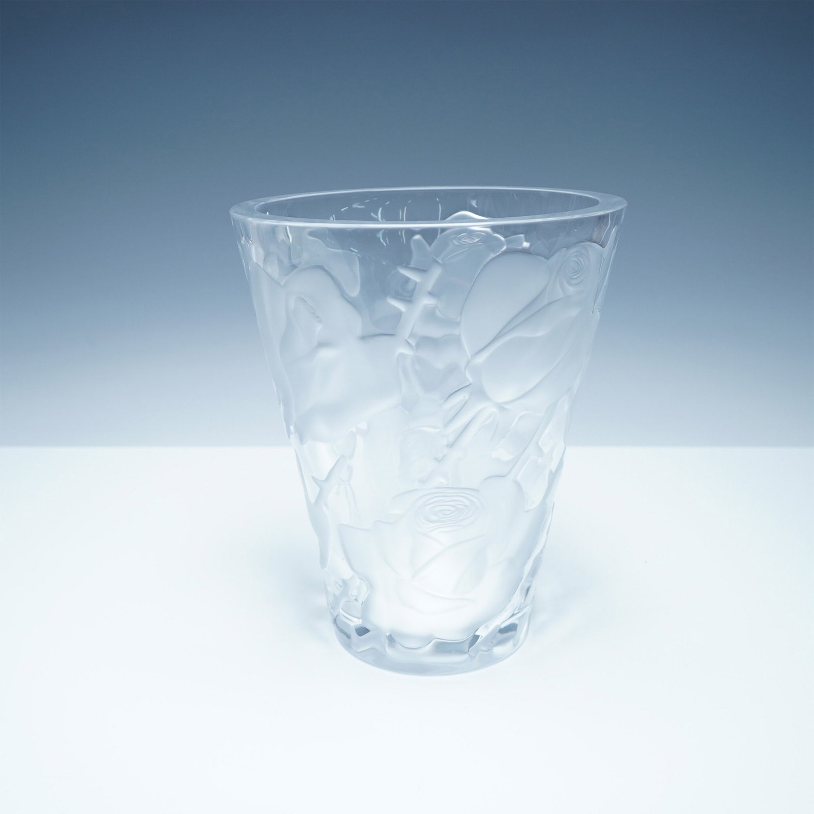 Lalique Ispahan Rose Frosted and Clear Crystal Vase: A stunning Lalique Ispahan Rose crystal vase featuring an elegant frosted and clear design with raised roses in high relief. The intricate craftsmanship highlights the delicate floral motif, capturing