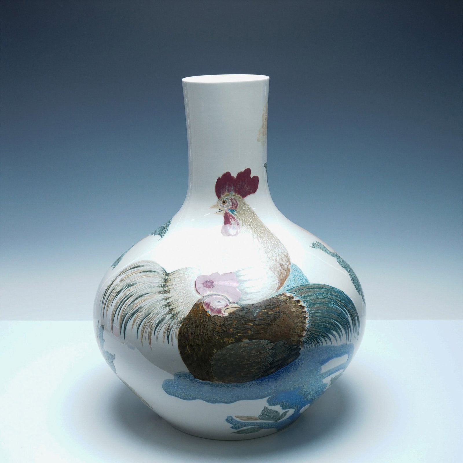 Lladro Porcelain Rooster Vase 01001138 : A striking Lladro Rooster Vase, beautifully decorated with an intricate hand-painted scene of a rooster and hen in a serene landscape. The traditional bulbous form with a slender neck enhances the ele