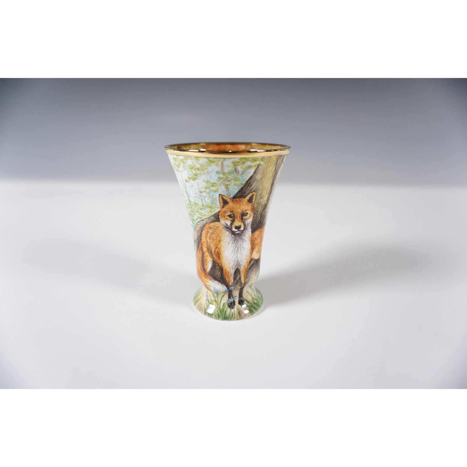 Moorcroft Enamel by Fiona Bakewell Fox Family Vase: A limited edition Moorcroft enamel vase designed by Fiona Bakewell. The exterior showcases a woodland scene with a family of foxes surrounded by blue foxglove flowers, while the interior reveals three
