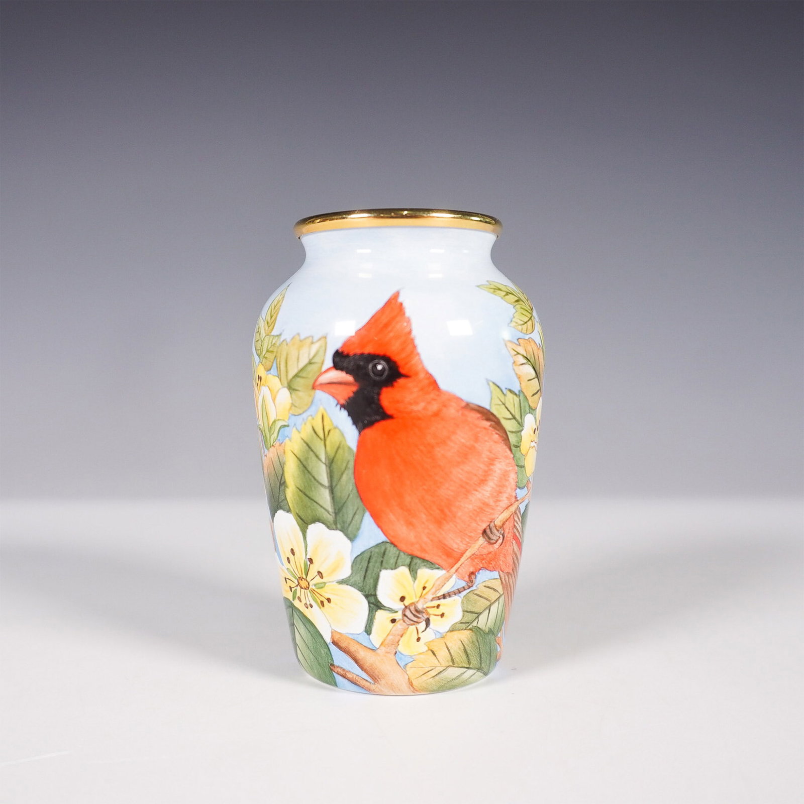 Moorcroft Limited Edition American Red Cardinal Miniature Vase: A Moorcroft limited edition mini vase, numbered 5/100, featuring the American Red Cardinal pattern. This beautifully hand-painted design showcases a vivid red cardinal perched among delicate yellow bl