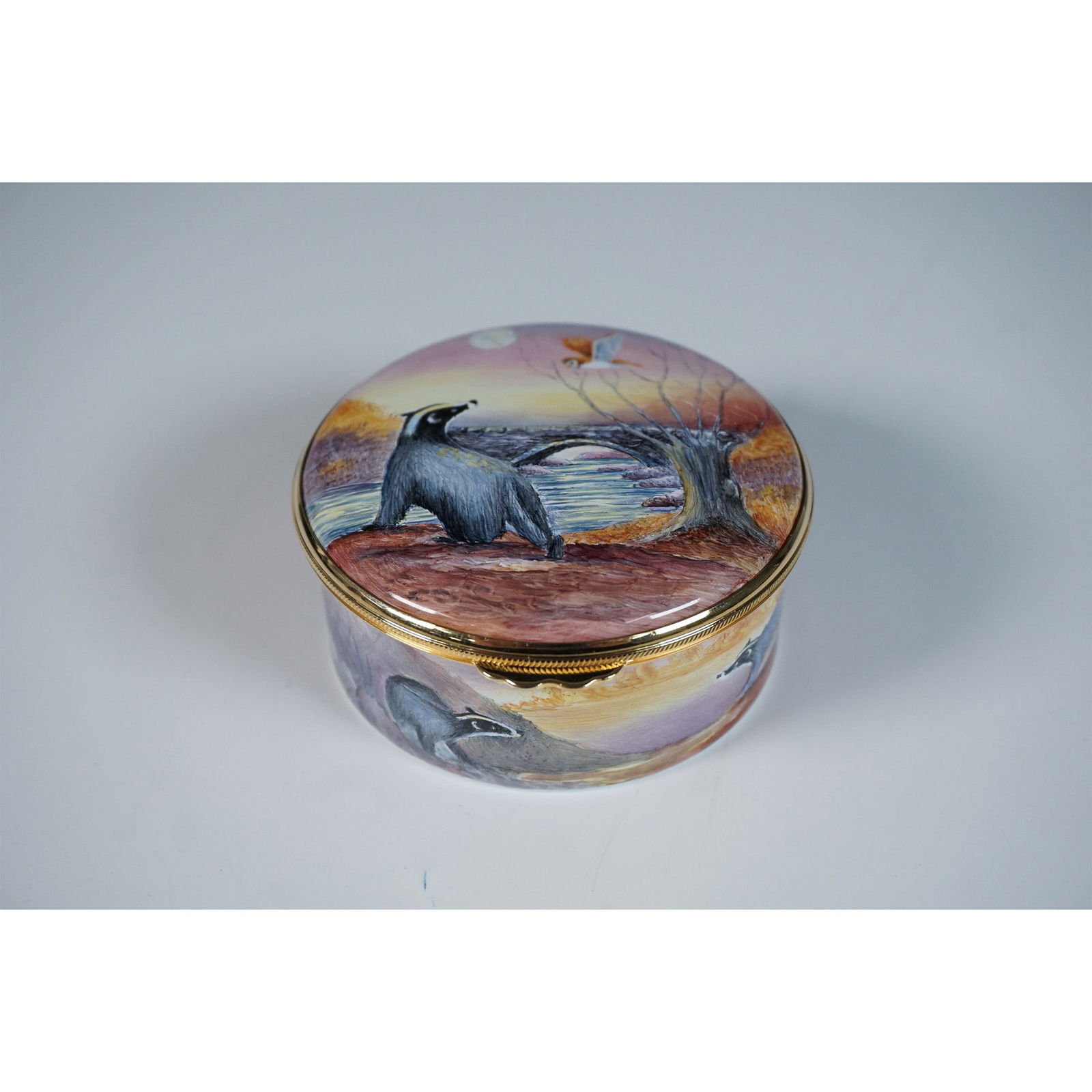 Moorcroft Enamel by Peter Graves Box, Badgers Moon: This Moorcroft enamel box is a limited edition collectible designed by Peter Graves. The piece is elegantly shaped with a rounded form and a hinged lid, creating a seamless and compact display. The ex