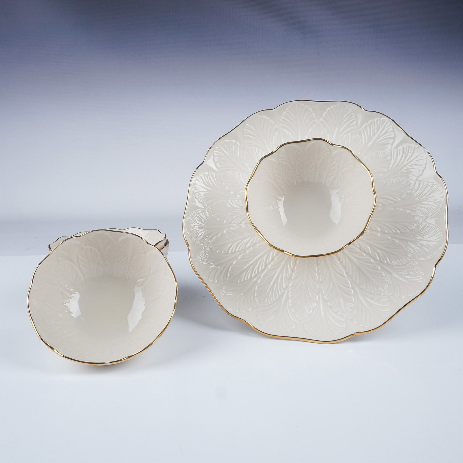 5pc Lenox Gilded Porcelain Bowls + Chip & Dip Server: A refined collection of Lenox porcelain featuring four bowls and a chip and dip server. This set showcases an elegant ivory finish adorned with intricate embossed details and accented by gleaming gilt