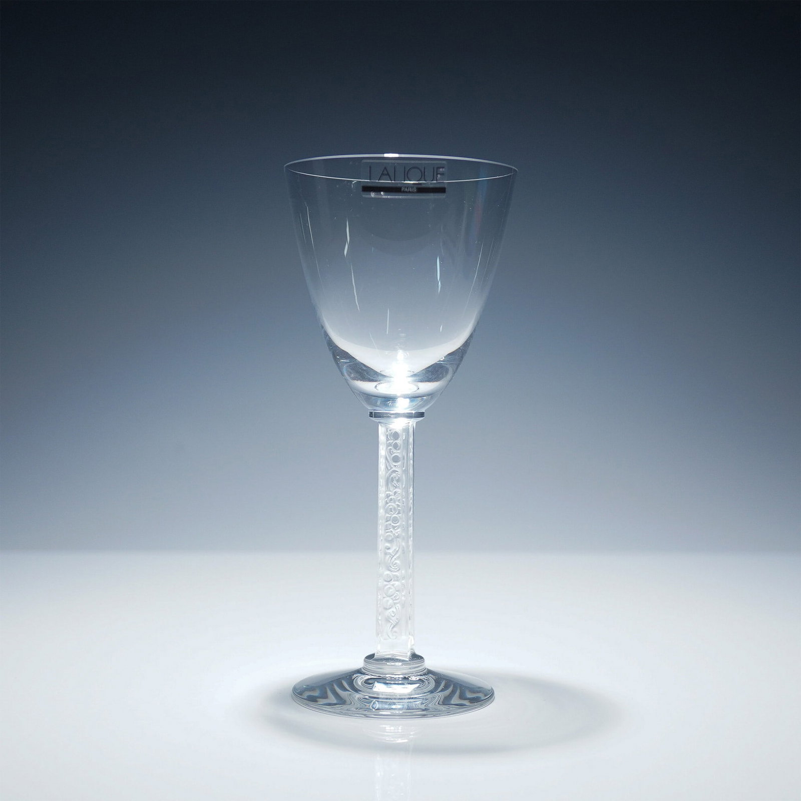 Lalique Crystal Phalsbourg Bordeaux Wine Glass with Box: This exquisite Lalique crystal Bordeaux wine glass from the Phalsbourg collection exemplifies refined French craftsmanship. Featuring a delicately etched stem with an elegant scroll and bubble motif, 