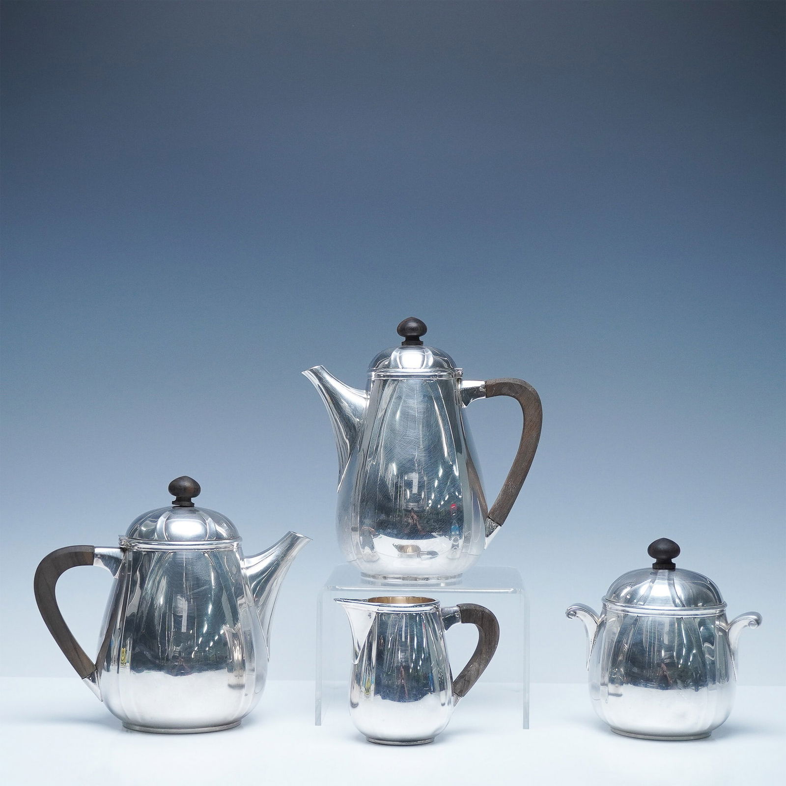 4pc Ravinet D'Enfert French Silver Plated Tea & Coffee Serving Set: A refined 4-piece silver-plated tea and coffee serving set featuring an elegant fluted design with wooden handles and finials. The set includes a coffee pot, teapot, creamer, and sugar bowl, each exhi