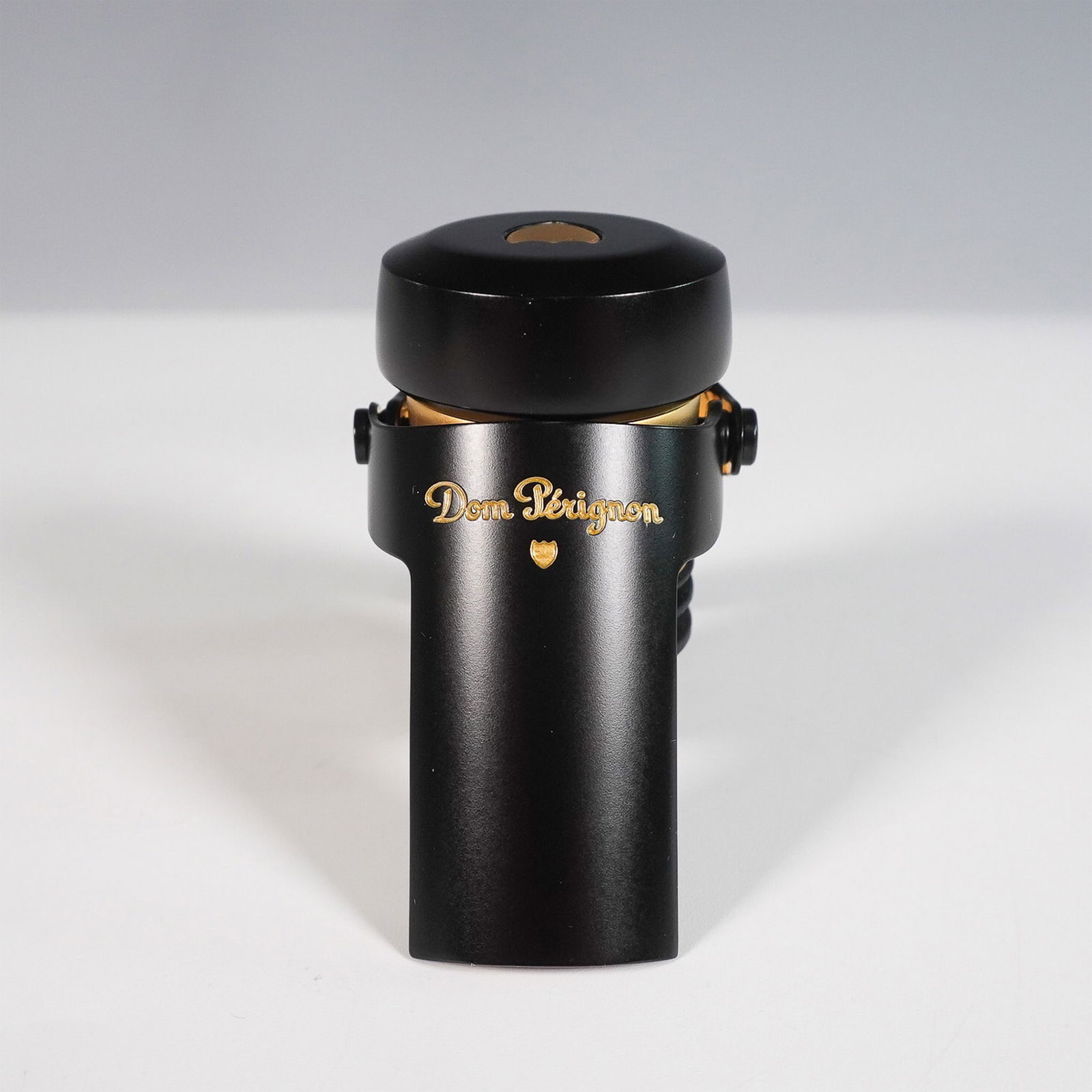 Dom Perignon Champagne Bottle Stopper: Luxury Dom Perignon champagne bottle stopper in an elegant black and gold finish. Designed to preserve the freshness and effervescence of opened champagne bottles, this high-quality stopper features a