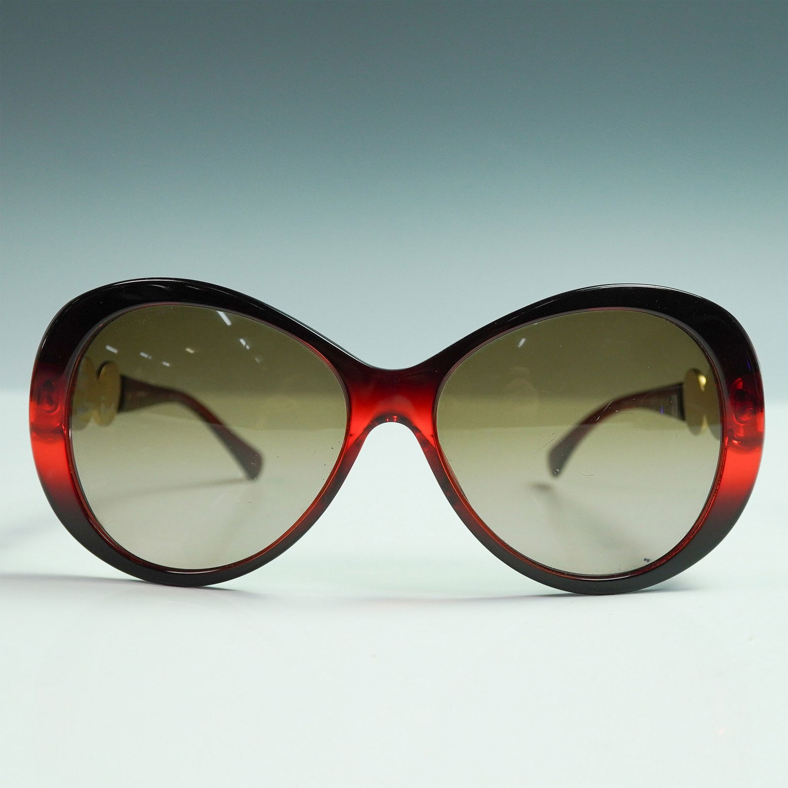 Versace Red Medusa Icon Sunglasses: Luxury designer sunglasses by Versace, model 4256-B, featuring an oversized butterfly silhouette with a rich red gradient frame. The temples are adorned with three prominent gold-tone medallions, each