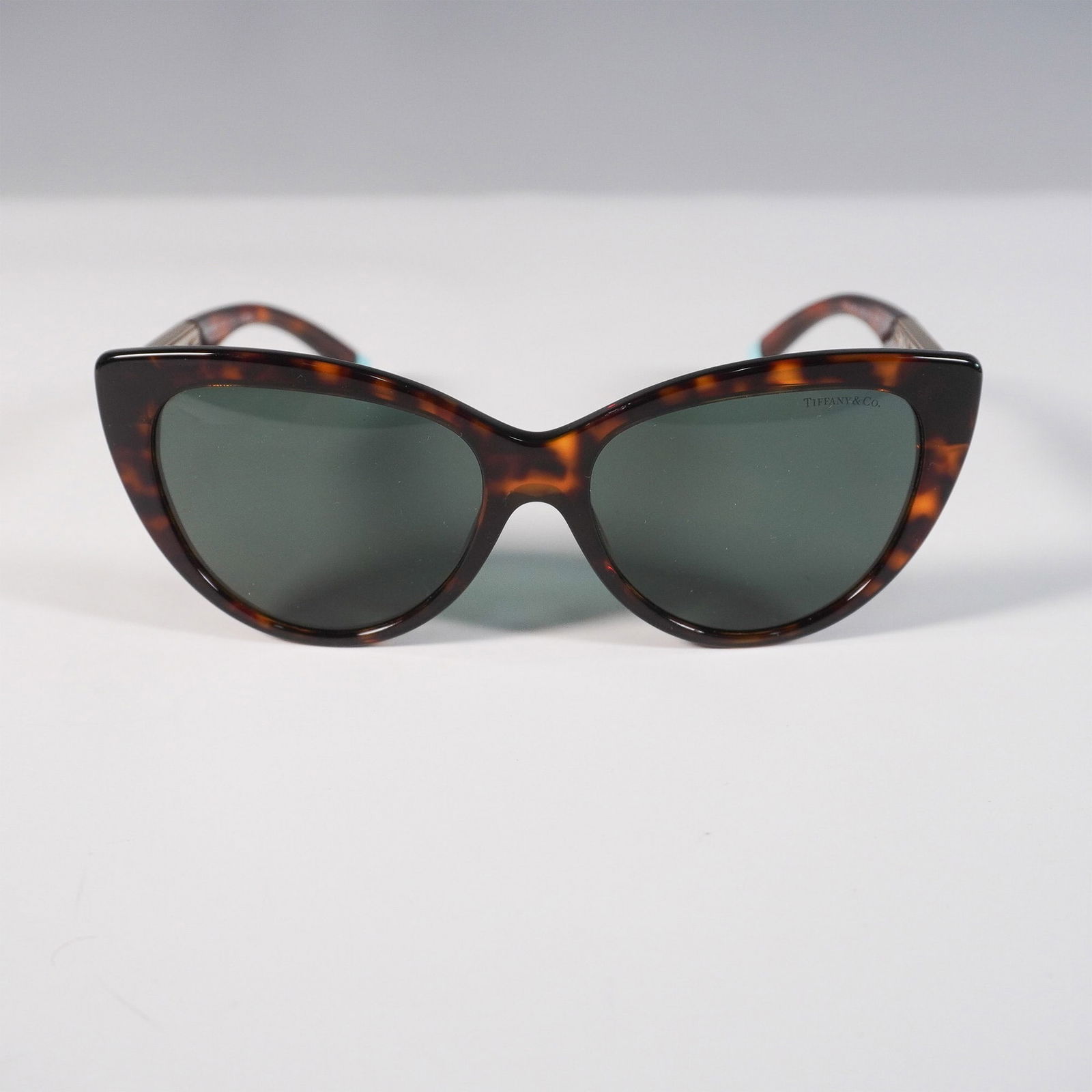 Tiffany & Co. Sunglasses, Tortoiseshell and Gold: Luxury Tiffany & Co. TF4196 sunglasses featuring a chic tortoiseshell frame with gold-tone metal accents on the temples, showcasing the brand's signature elegance. The cat-eye design is complemented b