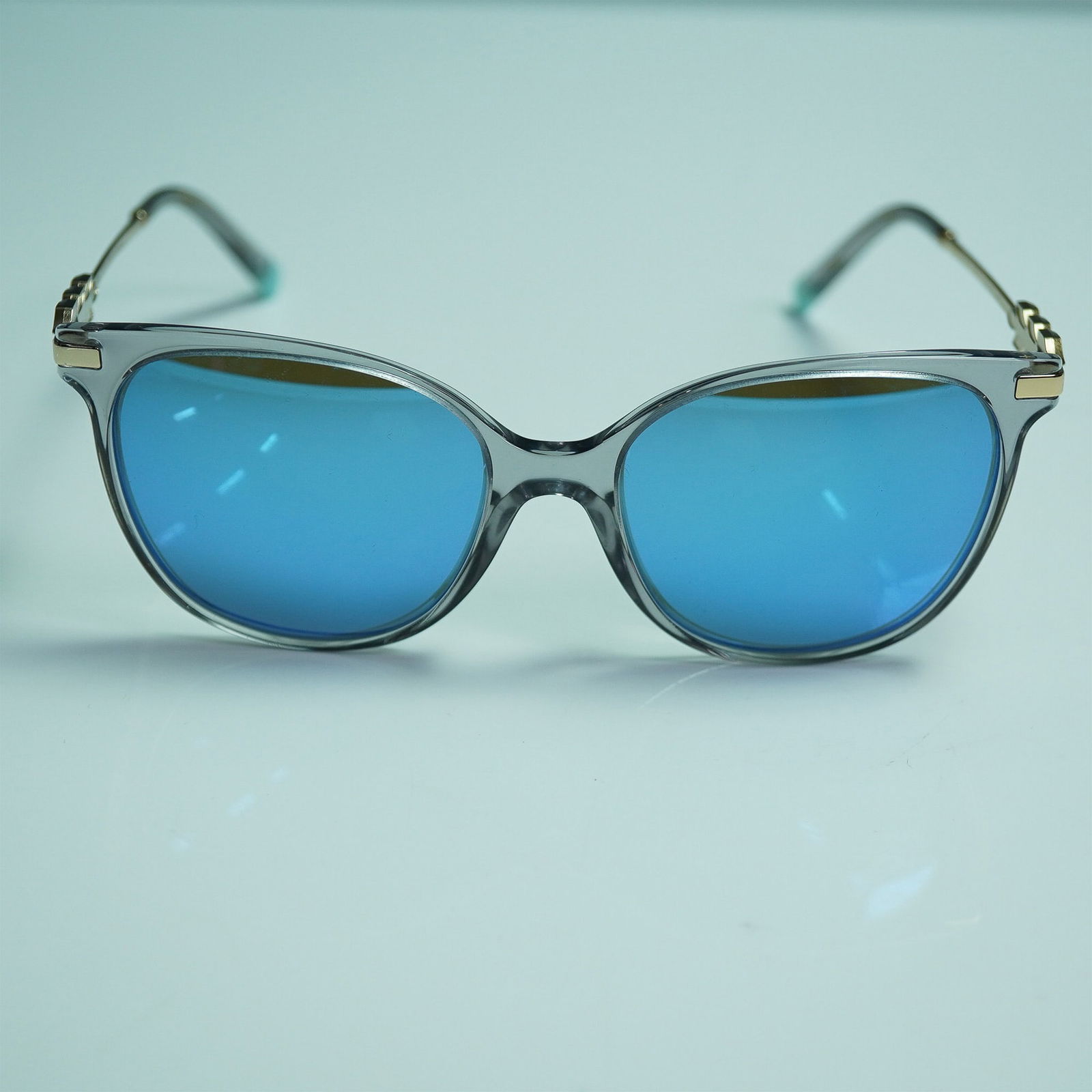 Tiffany & Co. TF 2220-B Sunglasses: Stylish Tiffany & Co. TF 2220-B sunglasses, made in Italy, featuring a gold-tone metal frame with signature wheat motif temples and blue gradient lenses. Marked 8270, a sophisticated blend of luxury a