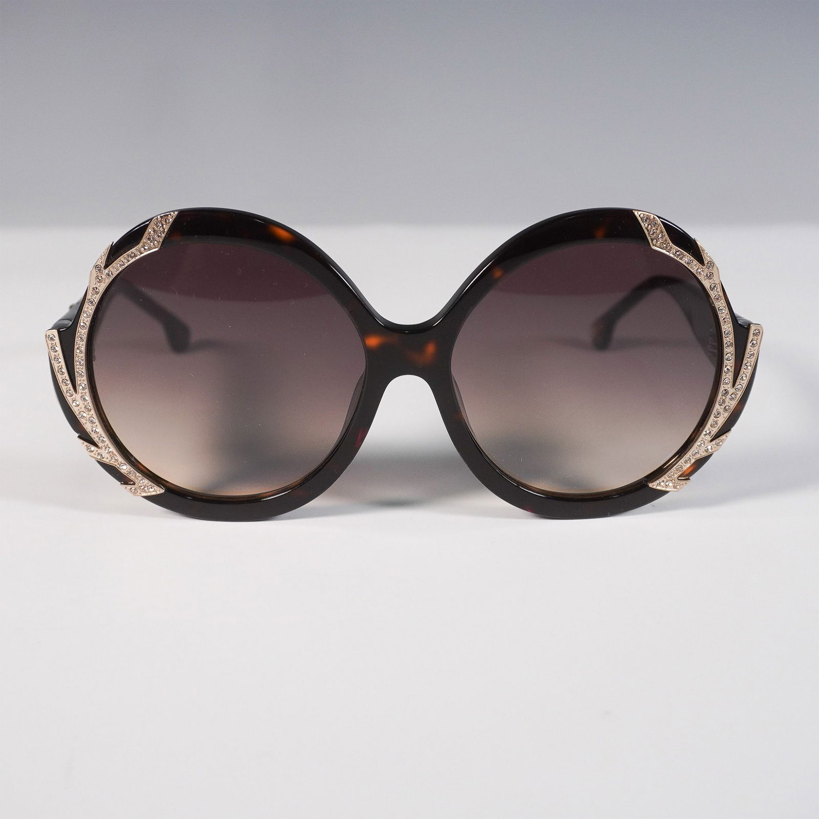 Alice + Olivia Stacey Crystal Oversized Sunglasses: Elegant Alice + Olivia Stacey Crystal oversized sunglasses featuring a bold round tortoiseshell acetate frame with sparkling crystal embellishments with a gradient brown lens. The luxurious gold-tone