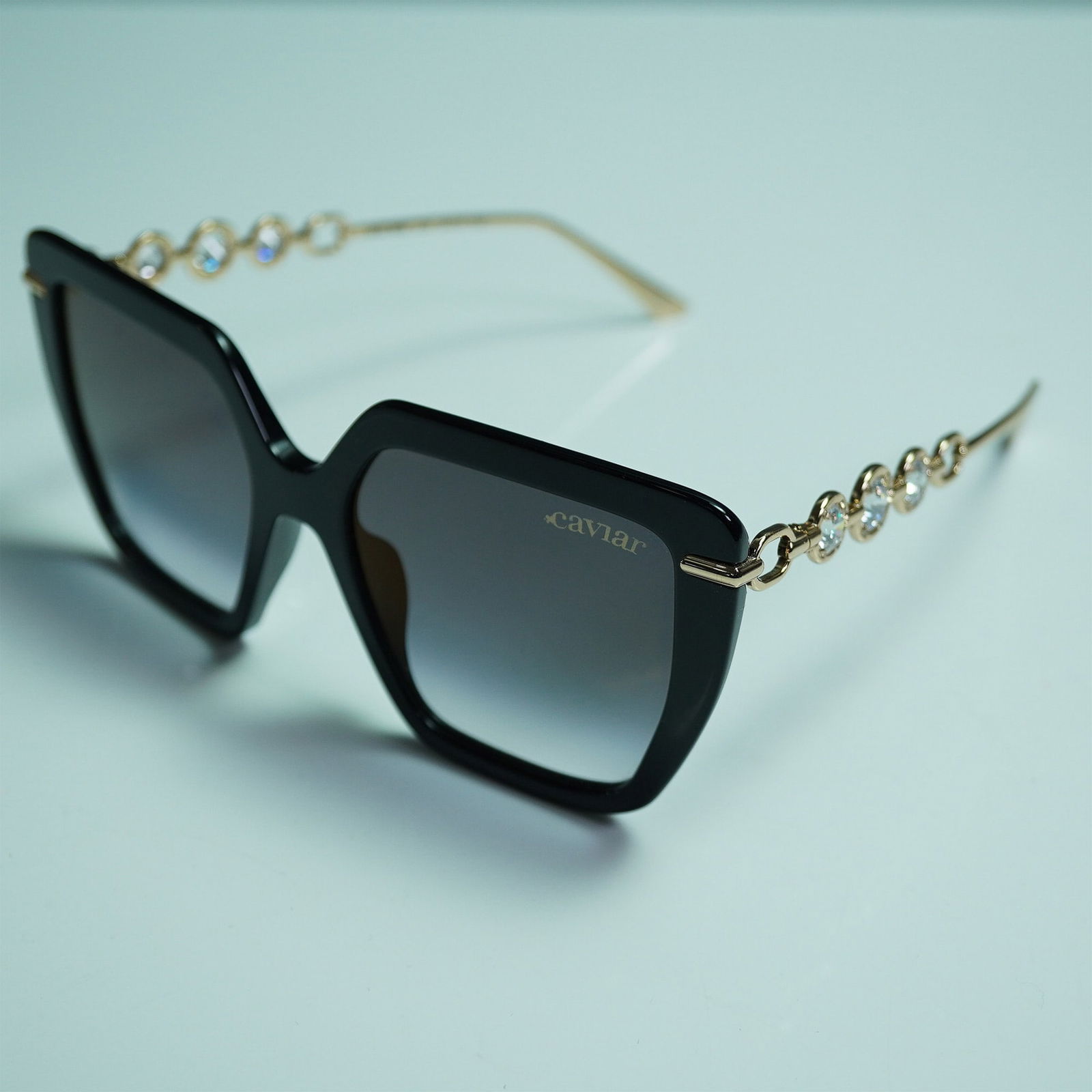 Caviar Champagne Series Sunglasses: Elegant Caviar Champagne Series sunglasses, model 6896, featuring a striking oversized black frame with gradient lenses. The gold-tone metal temples are adorned with dazzling crystal embellishments, c