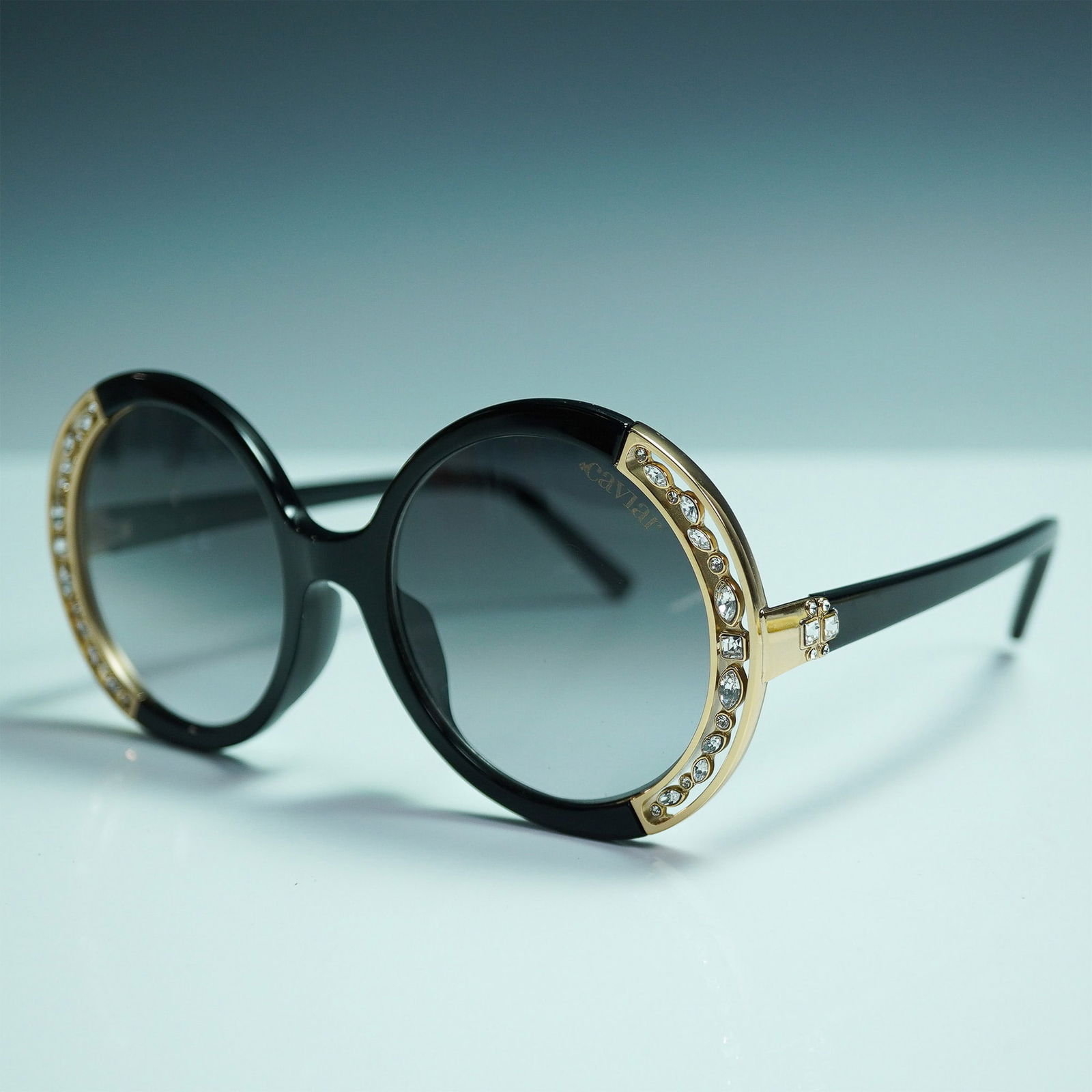 Caviar Champagne Series Italian Sunglasses, MOD.6887: These sunglasses feature a bold round black frame accented with gold-tone trim. The front frame is embellished with clear crystals in various cuts and sizes set into the gold-tone detailing. Additiona
