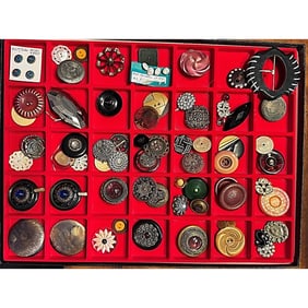 A Riker tray of assorted material buttons
