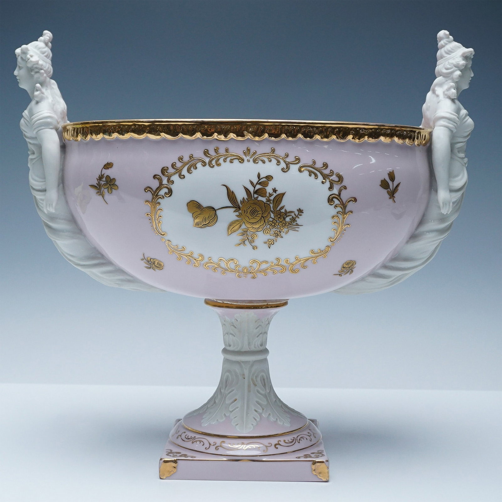 Ardalt Lenwile Porcelain Centerpiece Bowl with Figural Handles: Elegant Ardalt porcelain centerpiece bowl featuring delicate pink and white hues with gilded floral accents. This striking piece is adorned with sculpted figural handles in the form of classical femal