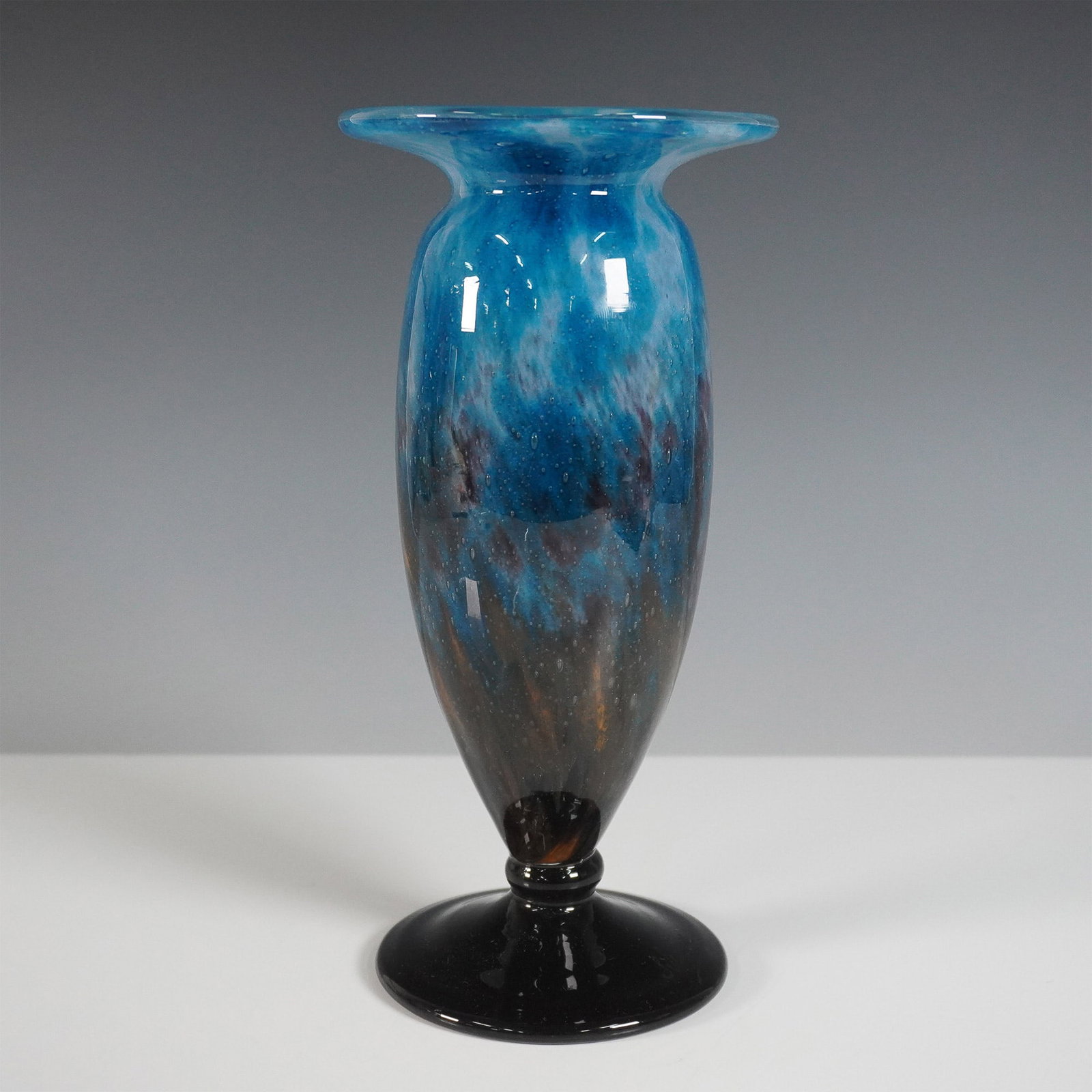 Schneider France Ovington Vase with Blue and Amber Swirl Pattern: A striking Schneider art glass vase featuring a beautifully mottled design with a rich blend of blue, amber, and black hues. This elegant piece has a flared rim and a tall, tapered body, resting on a 