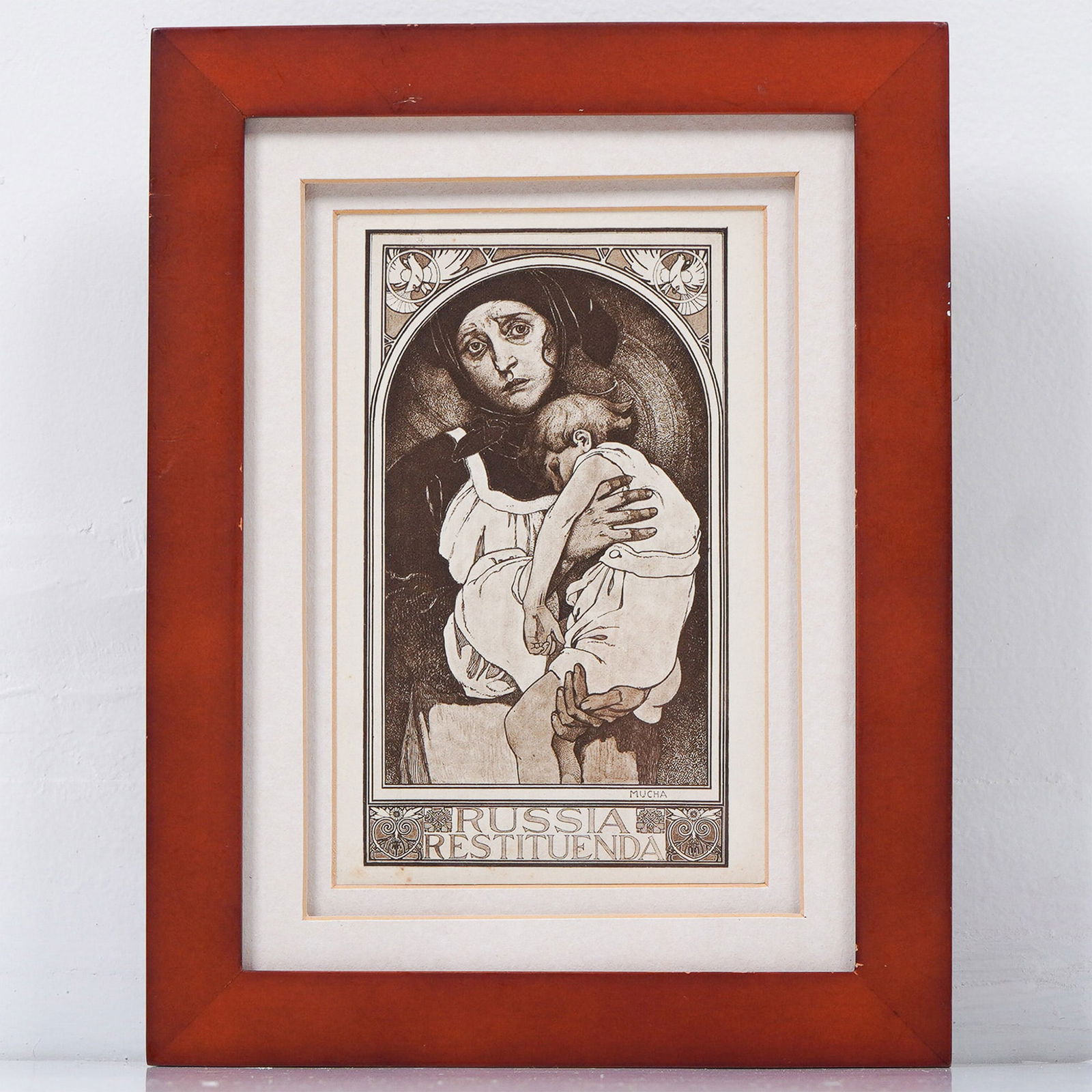Alphonse Mucha Print, Russia Restituenda: A framed print of "Russia Restituenda" by Alphonse Mucha, featuring a poignant depiction of a grieving mother holding a lifeless child. This monochromatic artwork, originally created as part of Mucha'
