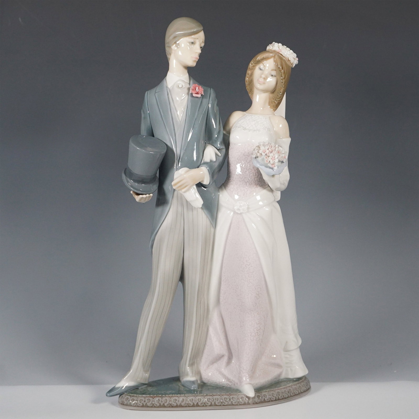 Lladro Porcelain Figurine, Matrimony 1001404: This elegant Lladro porcelain figurine, titled "Matrimony" (Spanish: Boda Arrogante), was sculpted by Juan Huerta and released in 1982 before its retirement in 1997. The composition captures a romanti