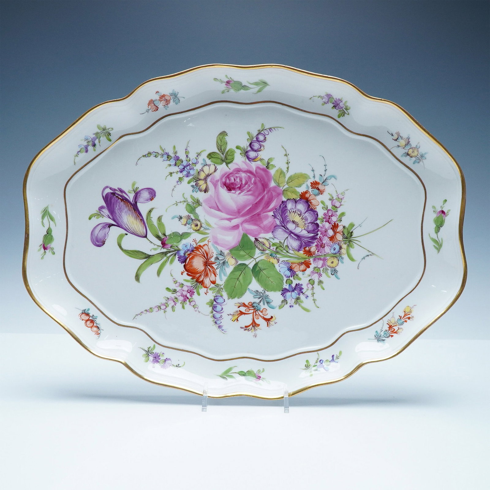 Meissen Hand-Painted Floral Porcelain Platter: Stunning Meissen porcelain platter featuring an elaborate hand-painted floral motif with vibrant hues of pink, purple, orange, and green. The scalloped edges are adorned with delicate gold trim, enhan