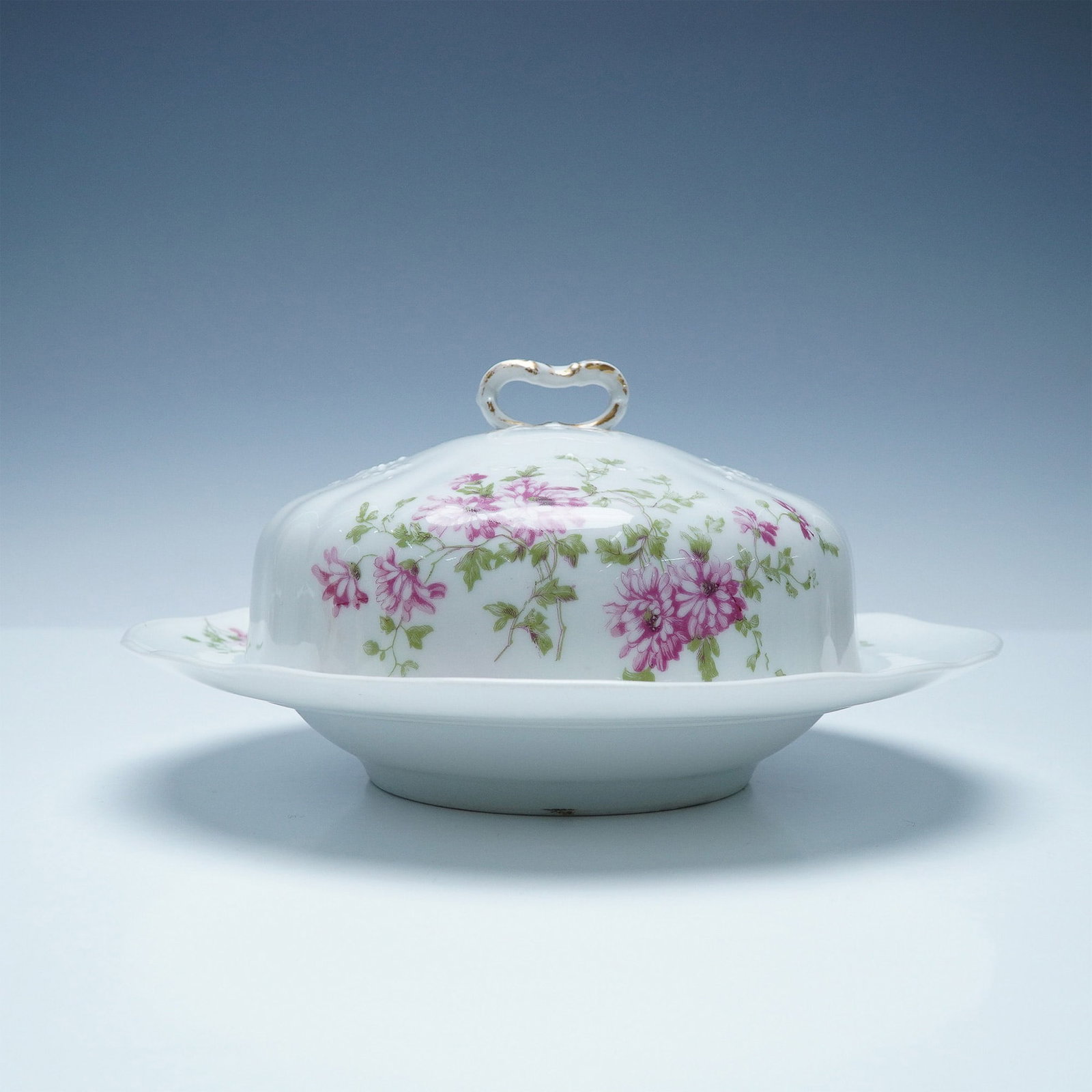 Charles Ahrenfeldt Limoges Porcelain Floral Butter Dish: This exquisite Charles Ahrenfeldt Limoges porcelain butter dish features a delicate floral motif with vibrant pink chrysanthemums and green foliage, beautifully hand-painted on a fine white porcelain 