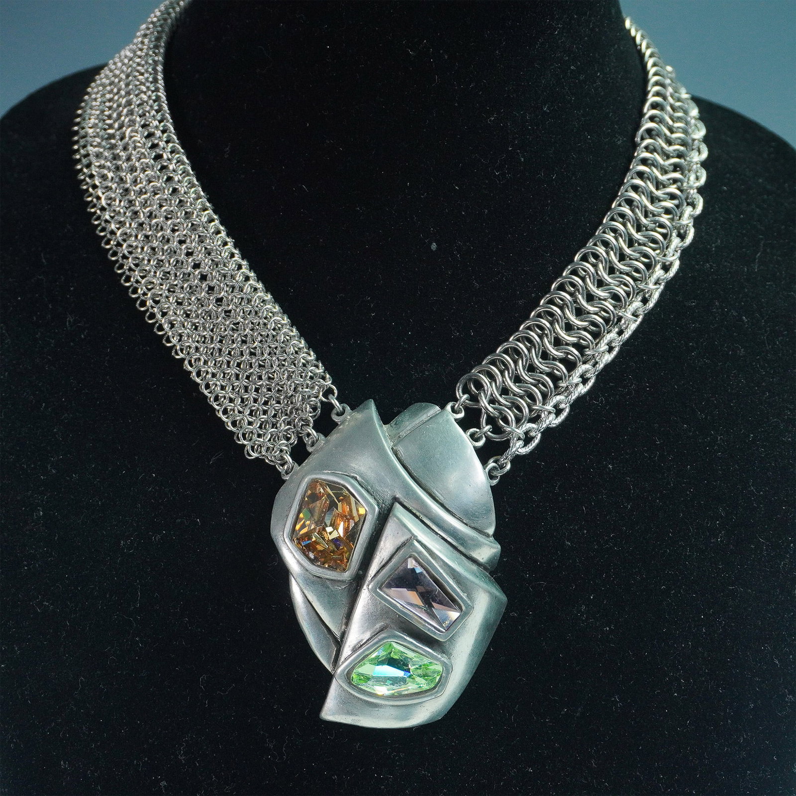 Connie Bates Trio, Multi-Chain Necklace with Sculptural Rhinestone Pendant: A bold and dynamic 18-inch multi-chain necklace featuring an array of silver-tone chains woven together for a layered effect. The striking sculptural pendant showcases an avant-garde design adorned wi