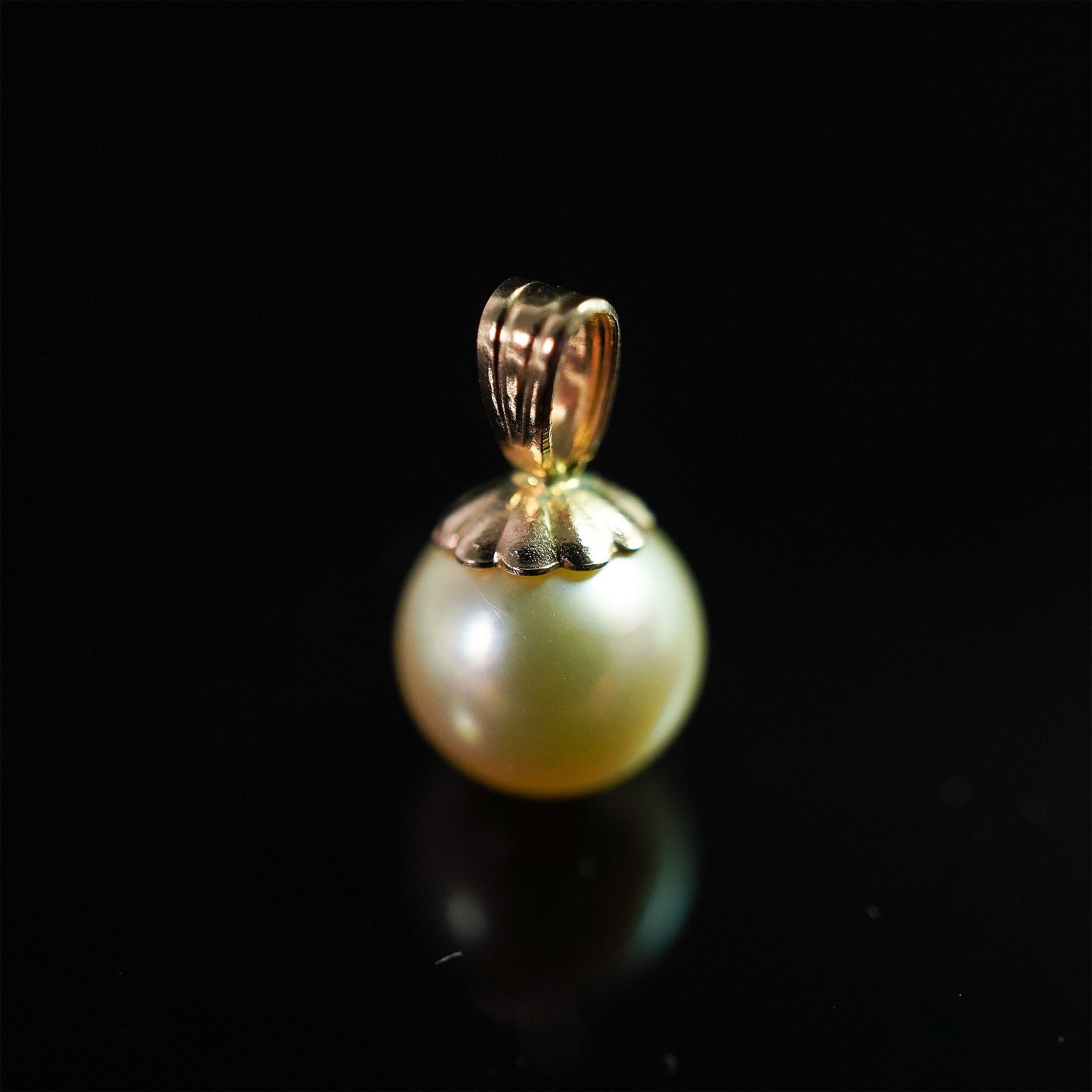 14K Gold and Pearl Pendant: A refined 14K gold pendant showcasing a luminous pearl, elegantly set with a delicate scalloped gold cap and bail. The pearl's soft, radiant glow pairs beautifully with the warm tones of the gold, cre