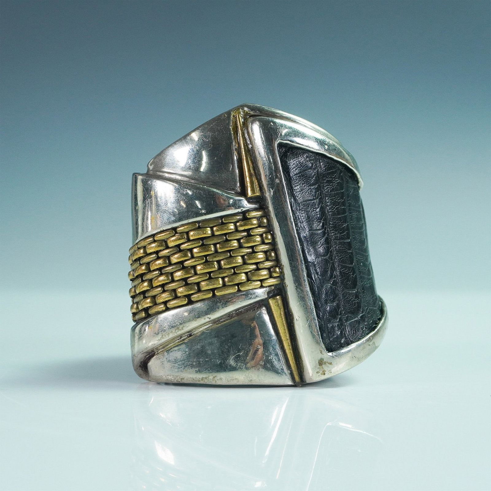 Connie Bates Lizard Embossed Leather and Metal Cuff Bracelet: A striking designer cuff bracelet by Connie Bates, featuring a bold combination of textured lizard-embossed black leather and sculptural metal accents. The asymmetrical design is crafted with a mix of