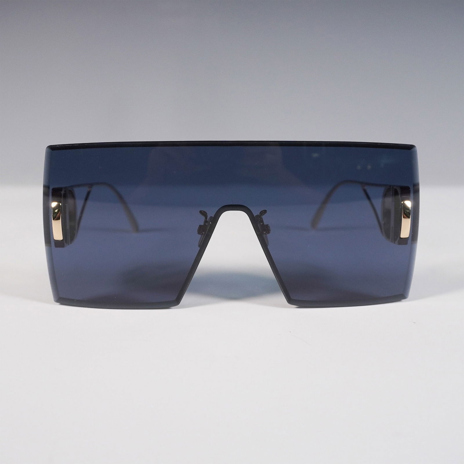 Dior 30 Montaigne Shield Sunglasses: Contemporary Dior 30Montaigne shield sunglasses featuring a striking blue single-lens visor design paired with slim gold-tone metal temples. The bold openwork temples are adorned with signature CD ini