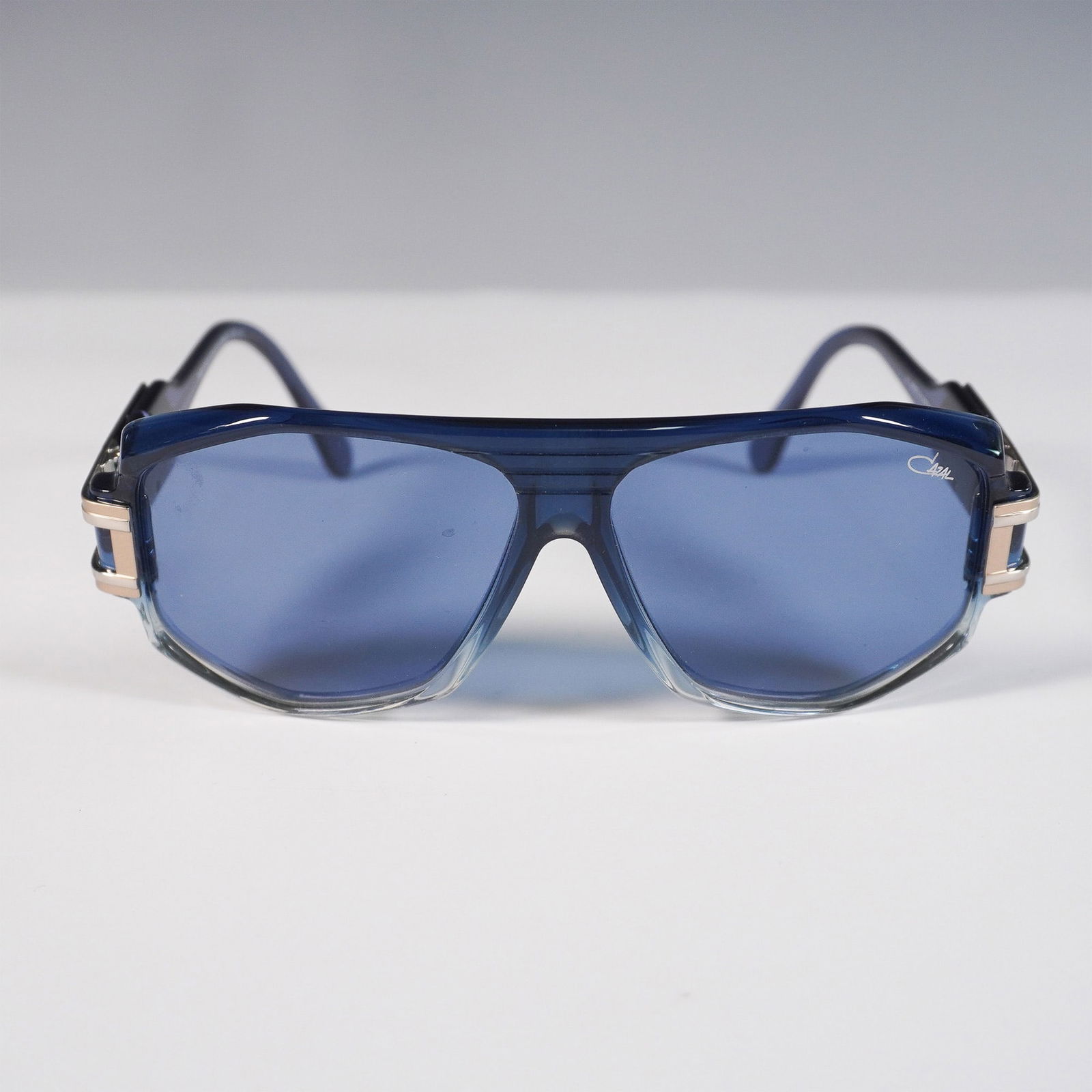 Cazal Legends 163/3 Sunglasses: Bold and distinctive, this pair of Cazal Legends 163/3 sunglasses features a translucent blue acetate frame with gold-tone and silver-tone accents. A standout in the Cazal Legends collection, the desi