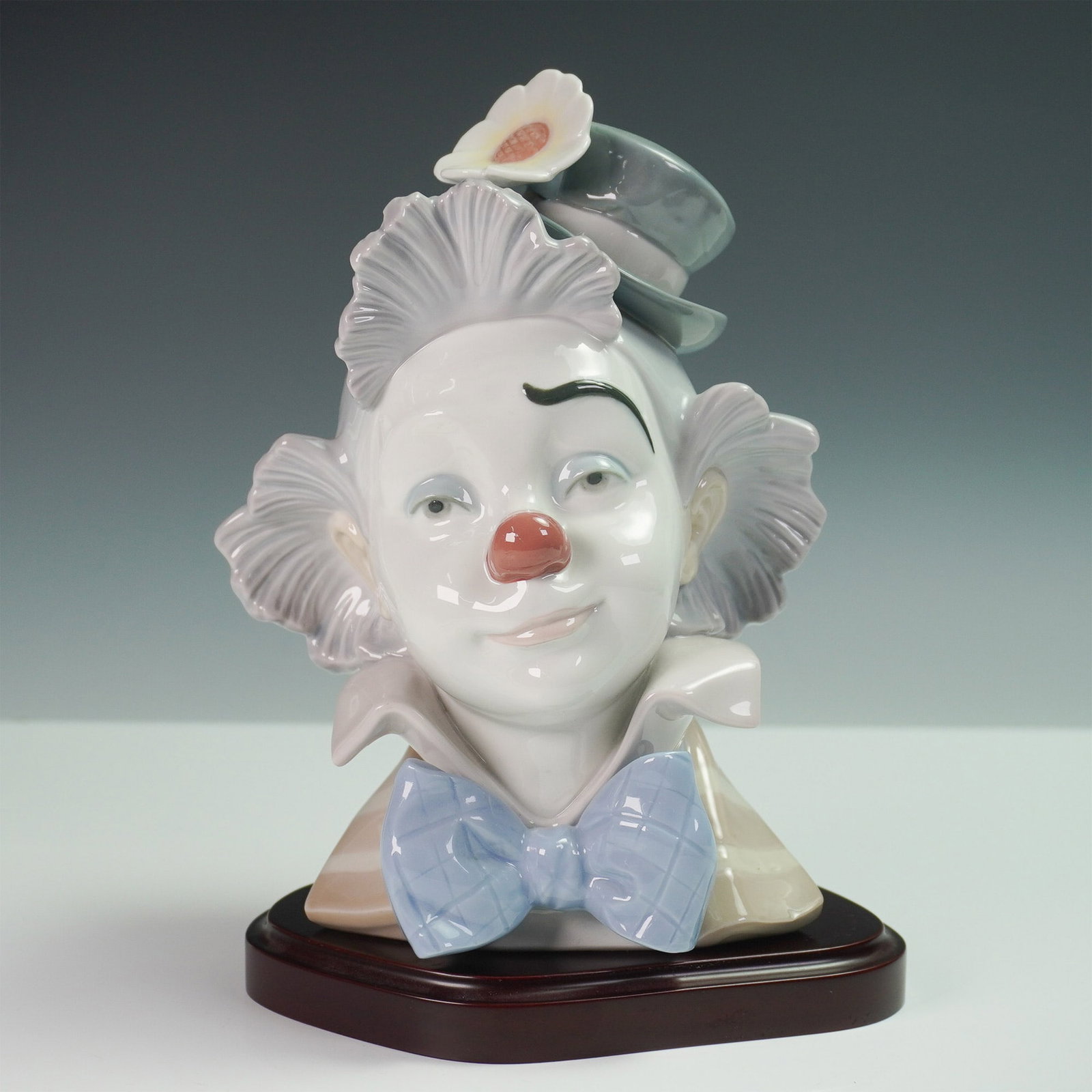 Lladro Porcelain Bust, Star Struck 1005610: Charming Lladro Star Struck clown bust, model 1005610, sculpted by Jose Puche and issued in 1989. This finely crafted porcelain sculpture captures the whimsical expression of a classic clown, featurin