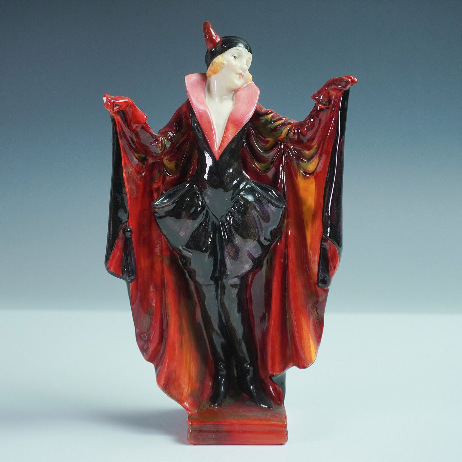 Royal Doulton Porcelain Figurine, Marietta HN1341: This elegant figure depicts the heroine of the 19th-century comic operetta Die Fledermaus, dressed in a striking bat costume. The theatrical black and red ensemble, complete with a flowing cloak and p