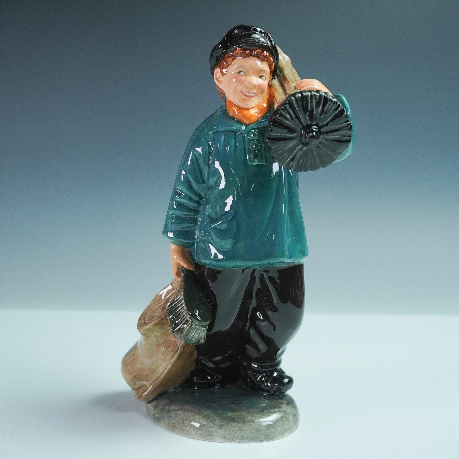 Royal Doulton Figurine Master Sweep HN2205: Royal Doulton figurine Master Sweep HN2205, designed by Mary Nicoll and issued between 1957 and 1962. This charming figure captures the essence of a young chimney sweep, dressed in traditional attire 
