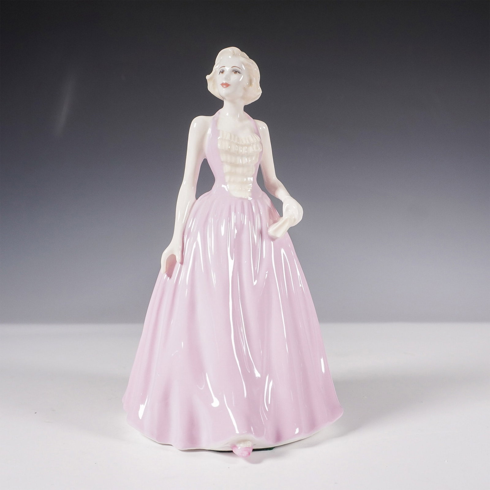 Royal Doulton Figurine, Dawn HN4603: Radiating timeless charm, Dawn HN4603 was designed by Nada M. Pedley and introduced in 2004 as part of the Royal Doulton Classics collection. This fine bone china figurine showcases a poised young wom