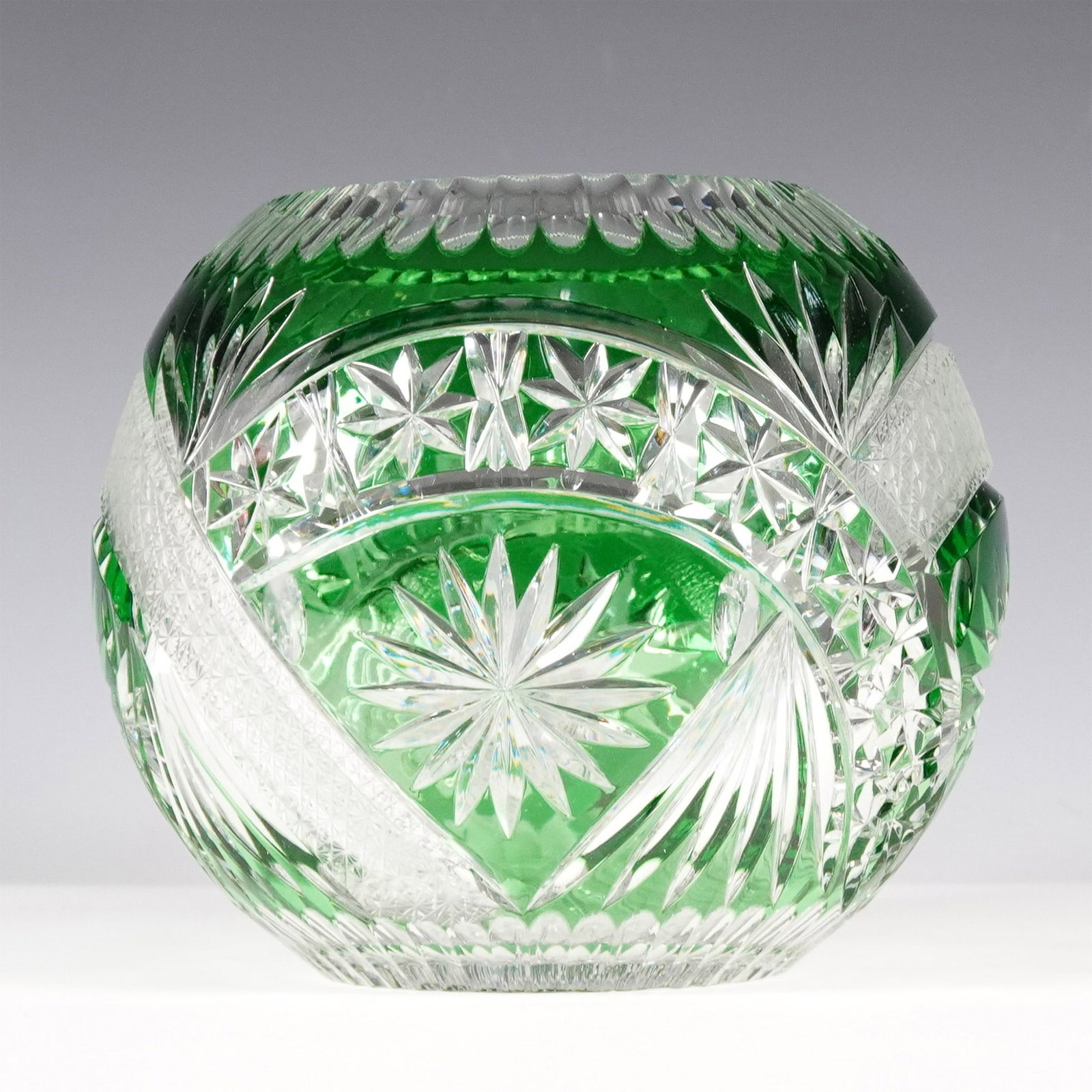 Bohemian Green Cut-to-Clear Crystal Bowl: A finely crafted Bohemian green cut-to-clear crystal bowl featuring an intricate geometric starburst and crosshatch pattern. The striking emerald green glass contrasts beautifully with precision-cut c