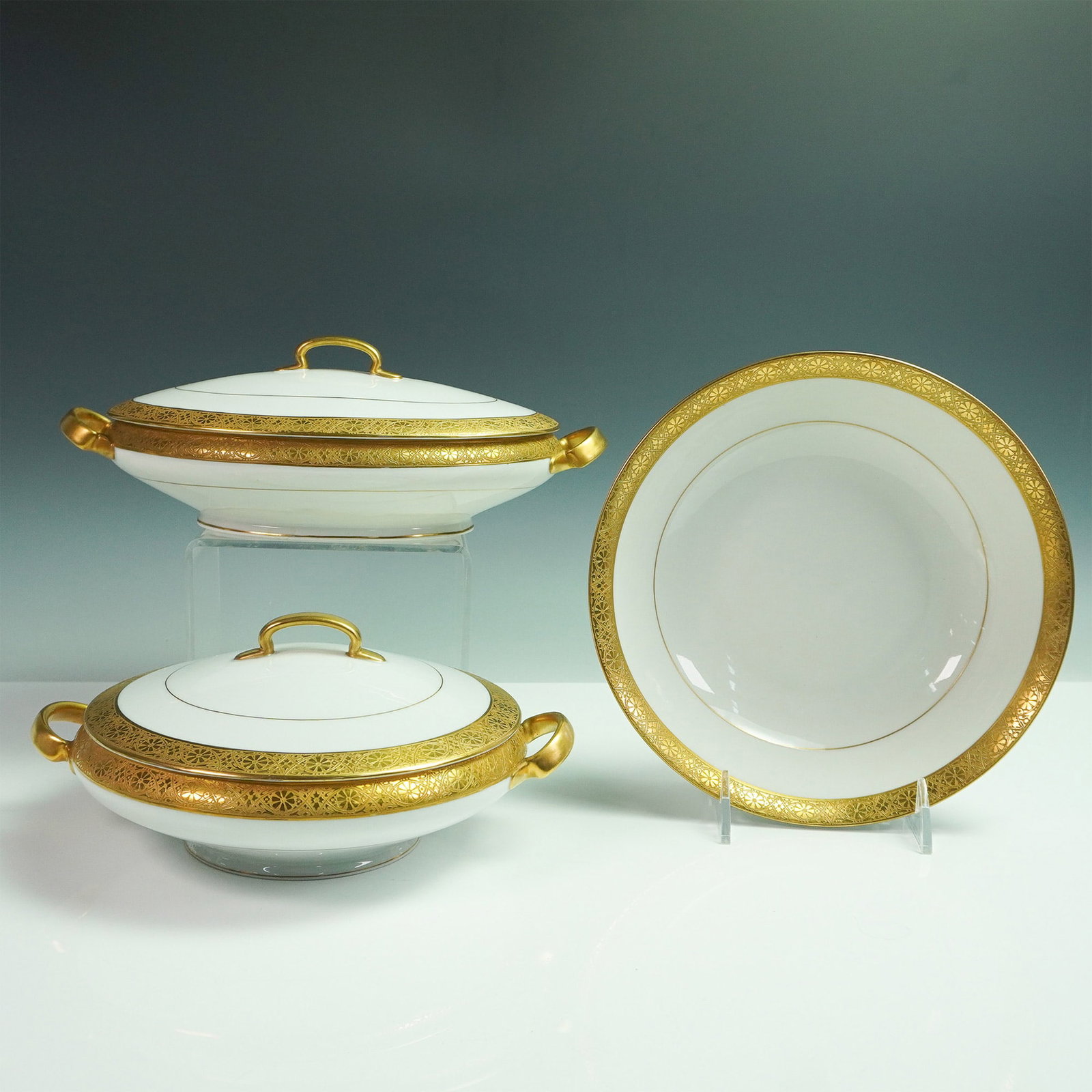 3pc Hutschenreuther Selb Bavaria Gold Rim Porcelain Serveware: Elegant 3-piece Hutschenreuther Selb porcelain set from Bavaria, featuring two lidded round vegetable tureens and one deep serving bowl. Each piece is embellished with a lavish gold encrusted border o