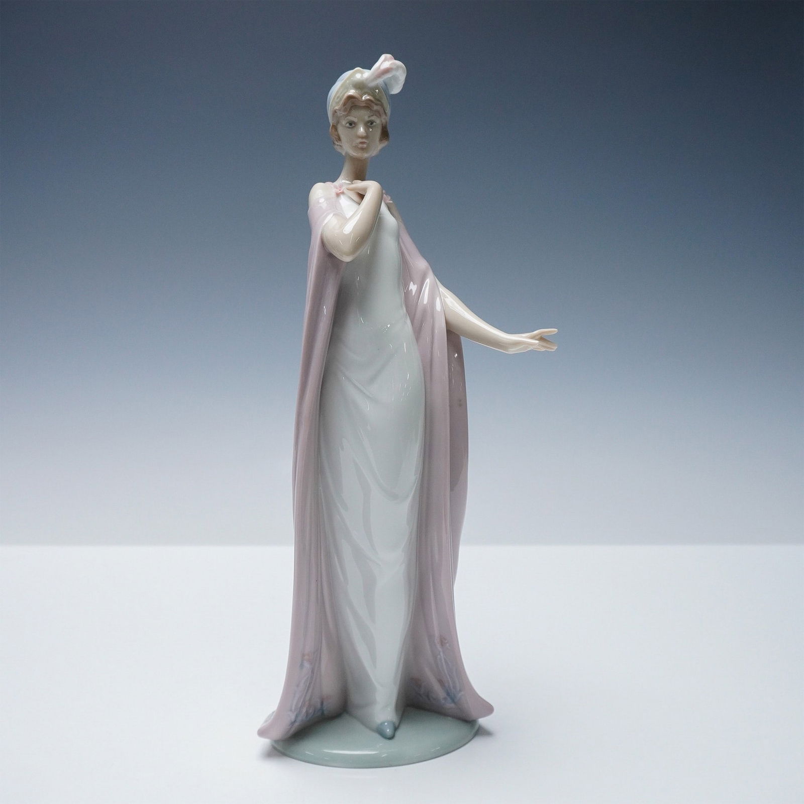 Lladro Porcelain Figurine, Breathless 1006403: Charming Lladro porcelain figurine titled Breathless, model number 1006403. Sculpted by Juan Ignacio Aliena, this graceful figure features a poised young woman draped in a flowing pale lavender robe o