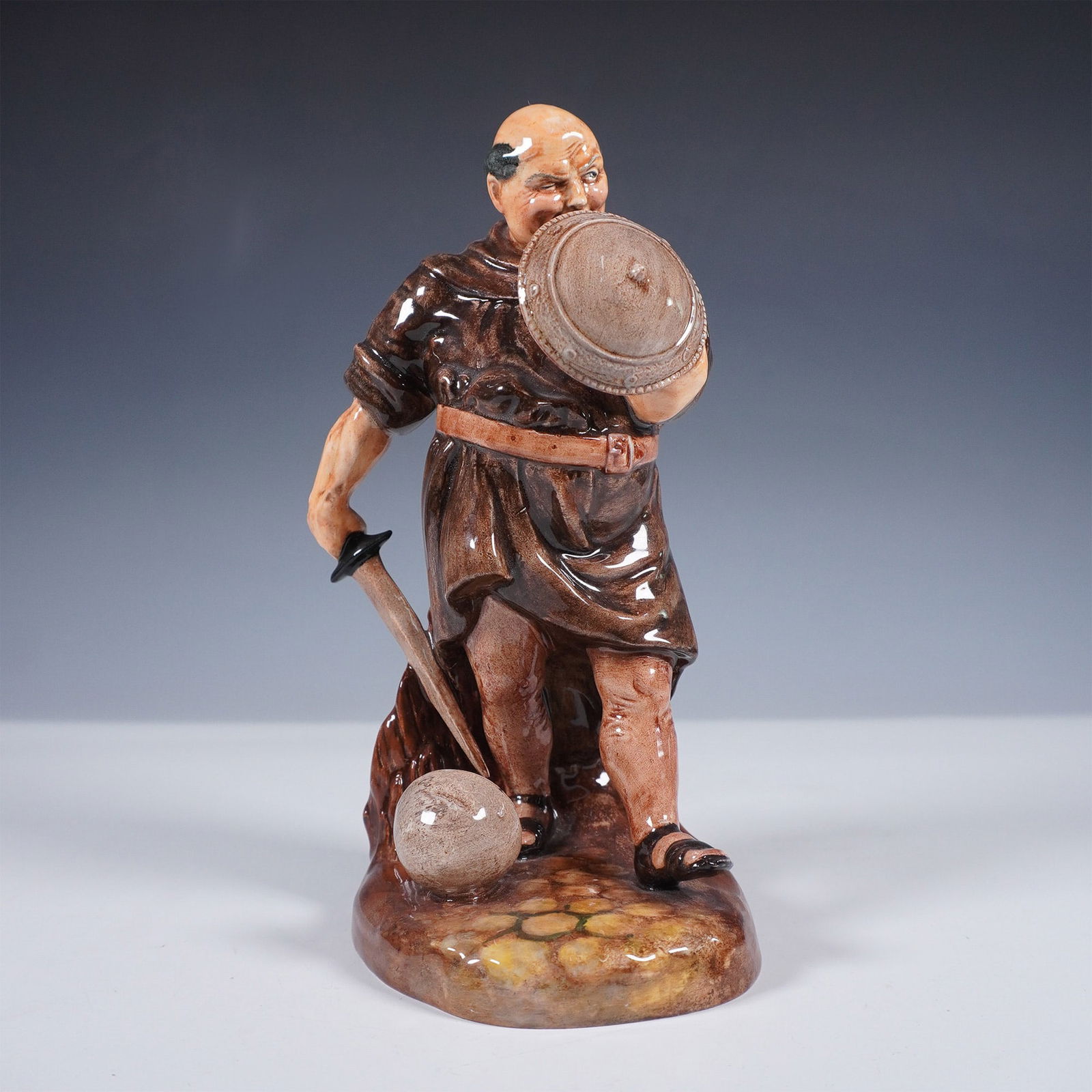 Royal Doulton Porcelain Figurine, Friar Tuck HN2143: This Royal Doulton figurine features Friar Tuck, the jovial and hearty companion from the Robin Hood legend. Dressed in a brown monk's robe and wielding a sword and shield, this hand-painted porcelain