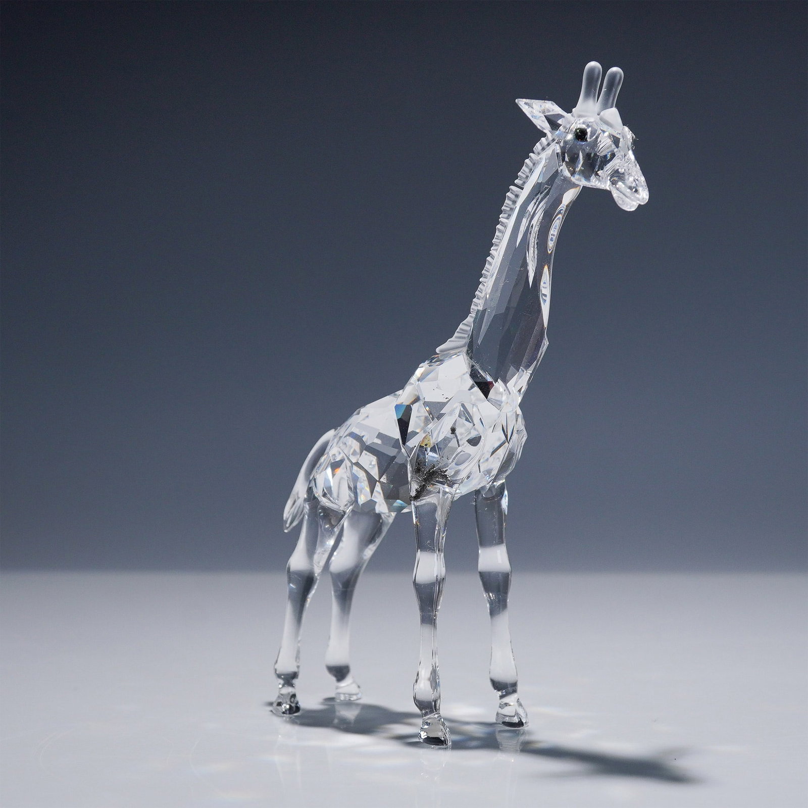 Swarovski Crystal Figurine, Giraffe Baby: Charming Swarovski Silver Crystal figurine titled Giraffe Baby, designed by Michael Stamey. This delightful piece was introduced in 1999 and retired in 2007, making it a collectible treasure for Swaro