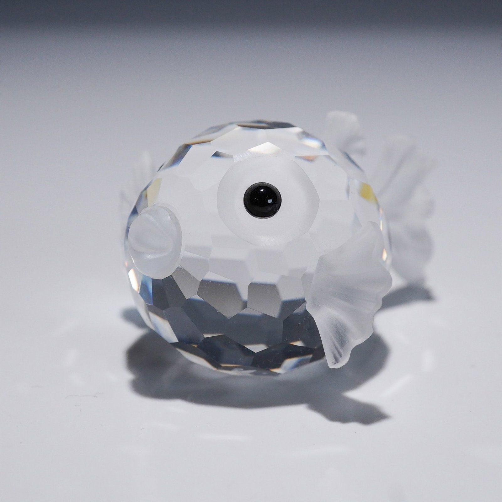 Swarovski Crystal Figurine, Small Blowfish: This retired Swarovski crystal Blowfish, part of the South Sea theme, is the middle-sized fish among the three blowfish produced by Swarovski. The faceted clear crystal body contrasts beautifully with