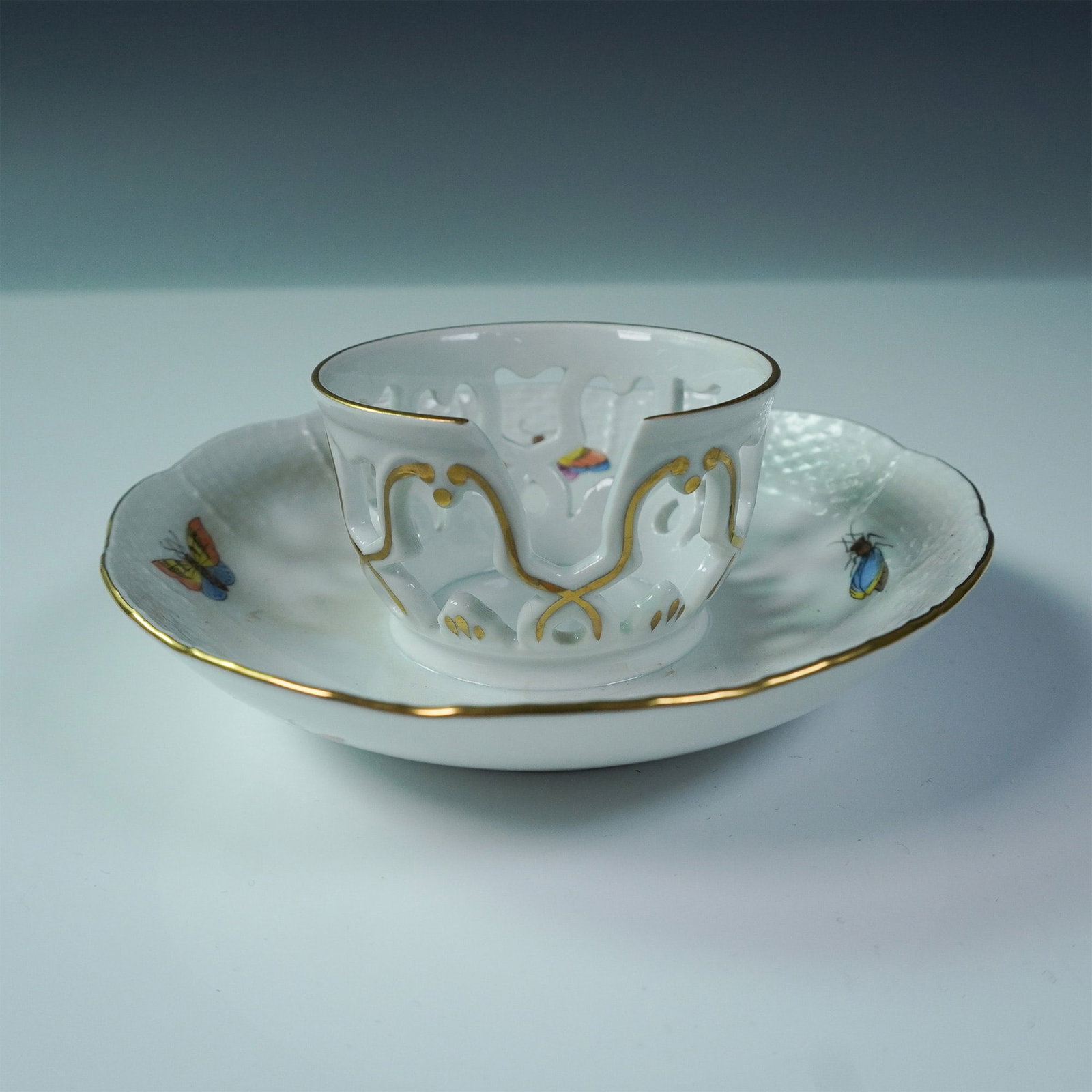 Herend Porcelain Trembleuse Cup and Saucer, Rothschild Bird: Handpainted Herend porcelain trembleuse cup and saucer set in the classic Rothschild Bird pattern. This elegant design features finely detailed birds, colorful insects, and rich gilt accents, with a p
