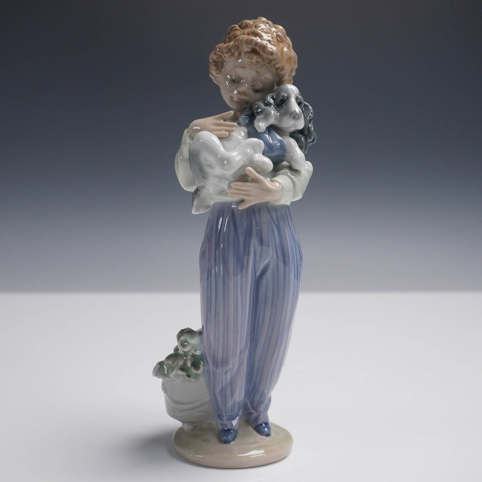 My Buddy 1007609 - Lladro Porcelain Figurine: This Lladro Collectors Society exclusive figurine, titled My Buddy, features a young girl tenderly holding a puppy. Sculpted by Antonio Ramos, the piece is finished in Lladro's signature glazed pastel