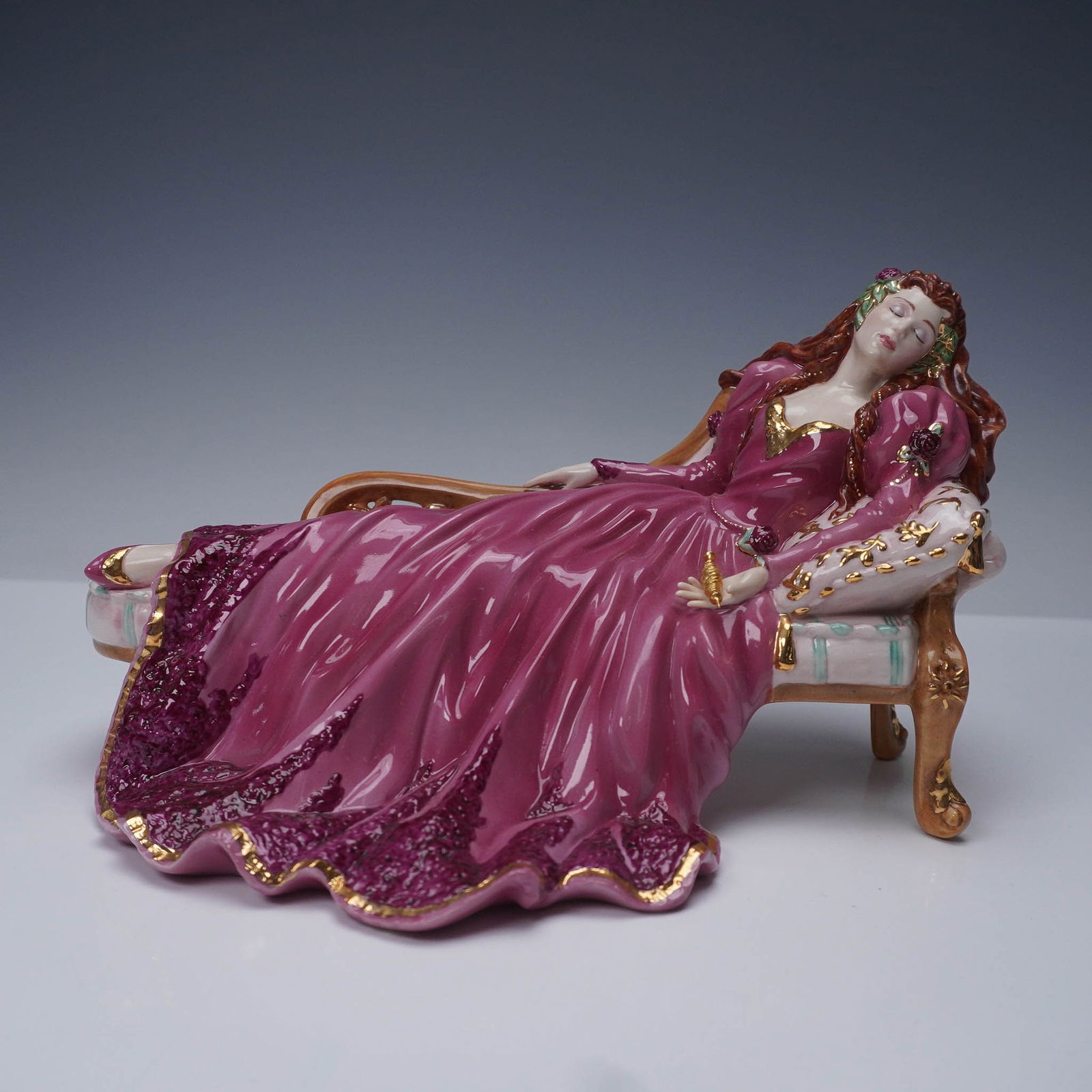 Franklin Mint Figurine, Sleeping Beauty: A Franklin Mint figurine titled Sleeping Beauty, designed by Gerda Neubacher and dated 1989. Crafted of fine material with a high-gloss finish, the princess reclines on a detailed chaise longue, adorn