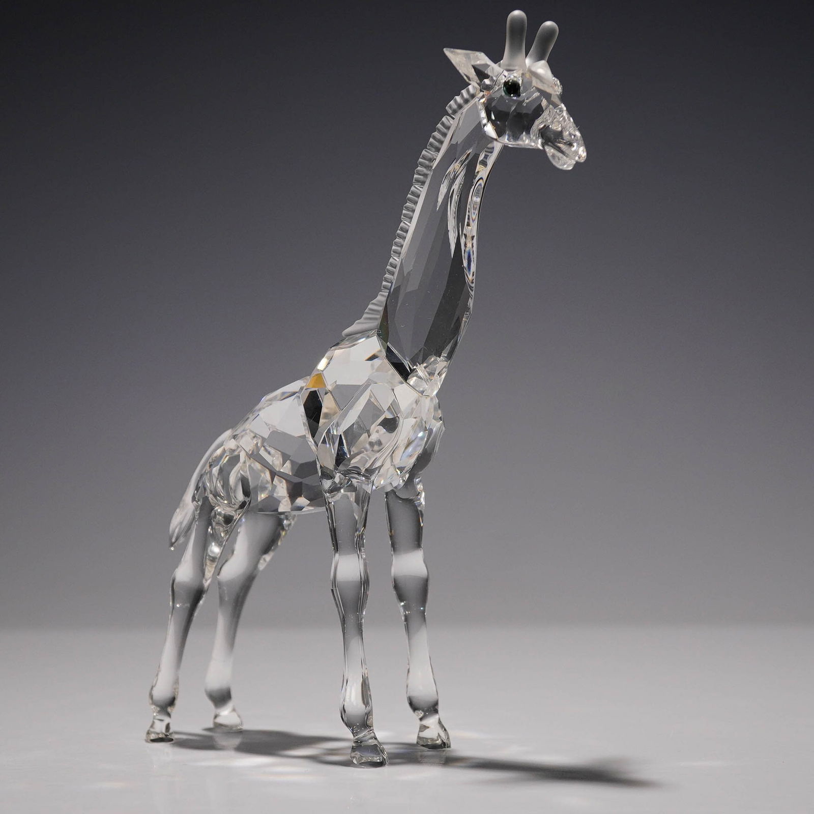 Swarovski Crystal Figurine, Giraffe Baby 236717: A Swarovski Silver Crystal figurine titled Giraffe Baby, item number 236717. This piece features a clear faceted crystal body with delicately sculpted detailing. Part of the African Wildlife series, i