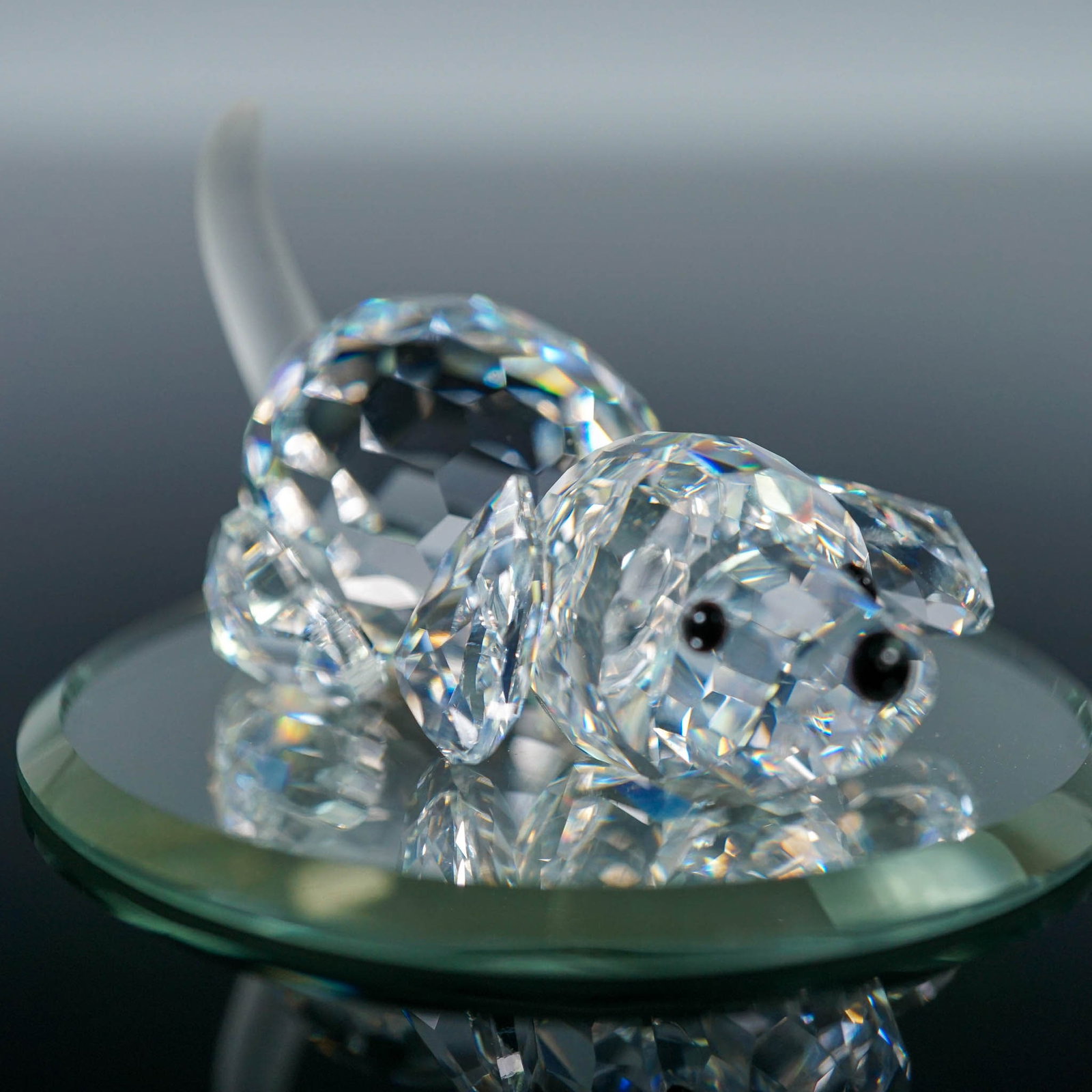 Swarovski Crystal Figurine, Beagle Puppy Playing & Mirror: This retired Swarovski crystal figurine depicts a playful beagle puppy lying in a prone position, poised as if ready to leap into action. Introduced as part of the Peaceful Countryside theme group, th