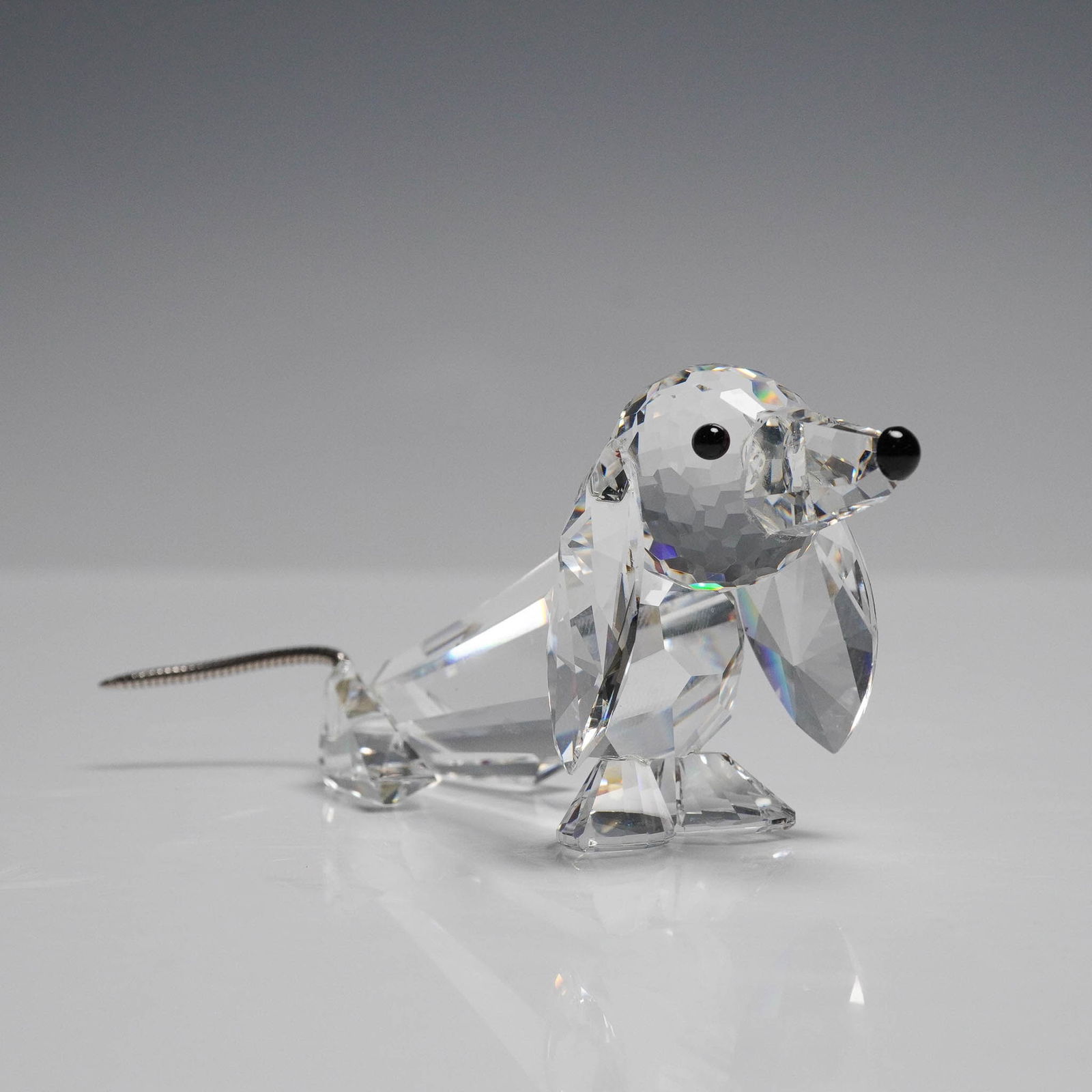 Swarovski Crystal Figurine, Dachshund Dog: Swarovski Silver Crystal Dachshund figurine, featuring a charming long-bodied dog with faceted clear crystal throughout and long, drooping ears. Accented with black crystal eyes and nose and a delicat