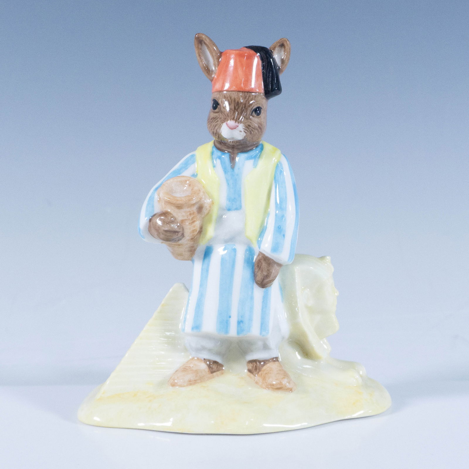Egyptian DB314 - Royal Doulton Bunnykins: A figure dressed in traditional clothing, standing next to the Great Sphinx of Giza. Royal Doulton backstamp. Artist: C. Dadd Issued: 2004 Dimensions: 4.5"H Country of Origin: England